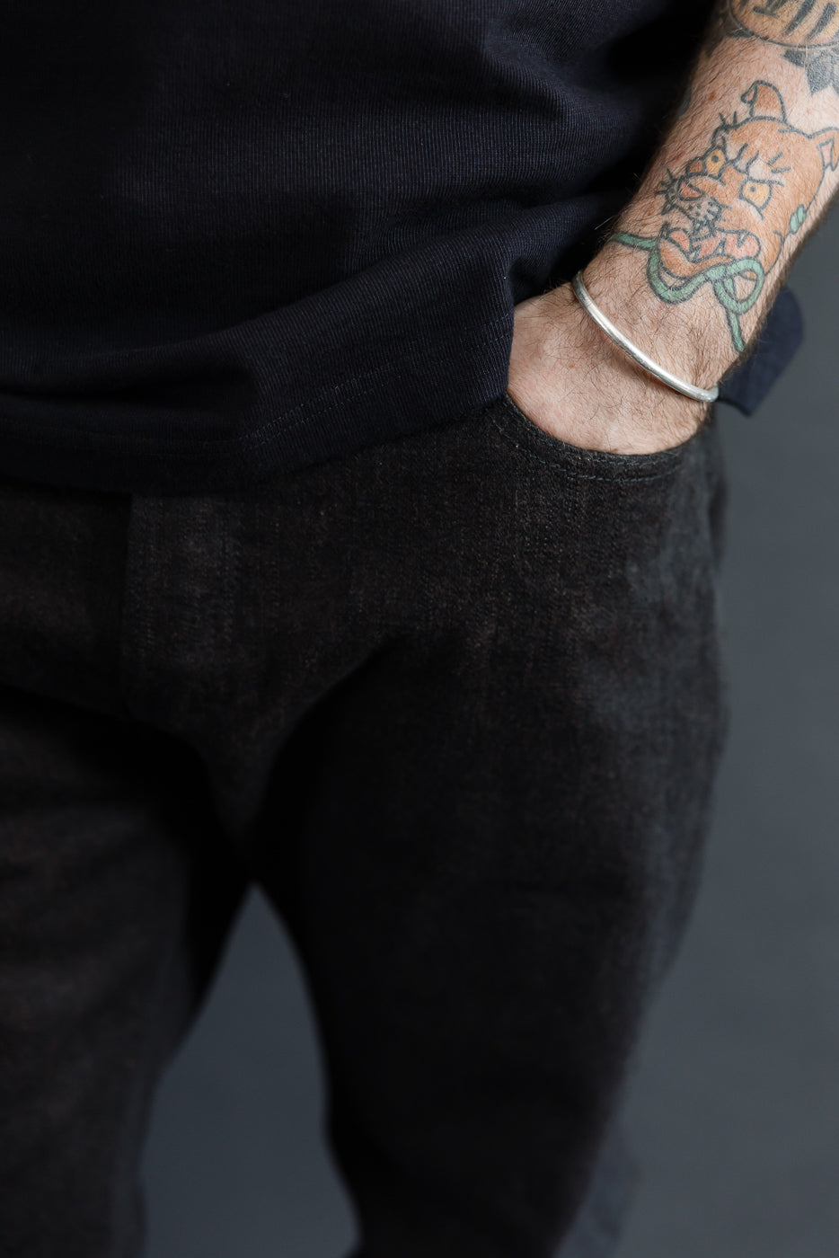Close-up front view of black selvedge pants, male model 5'9