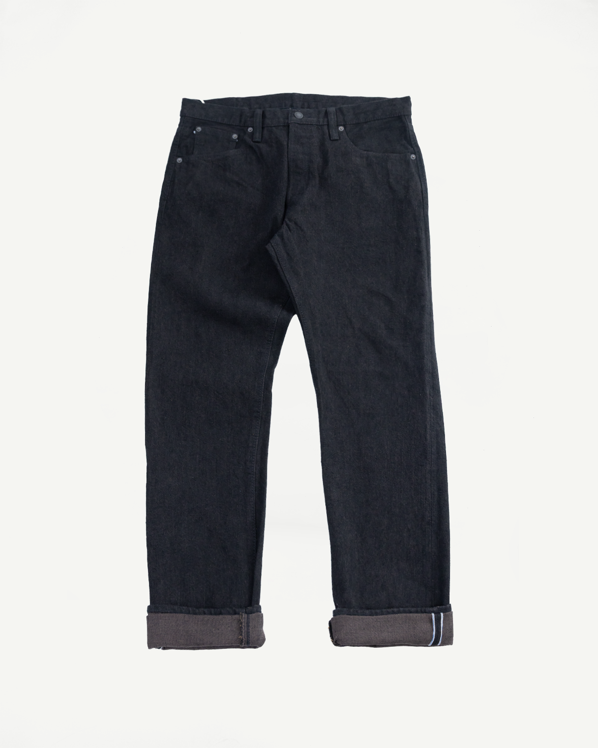 Dark selvedge denim jeans, front flat lay, cuffed hems showing selvage edge, classic 5-pocket design
