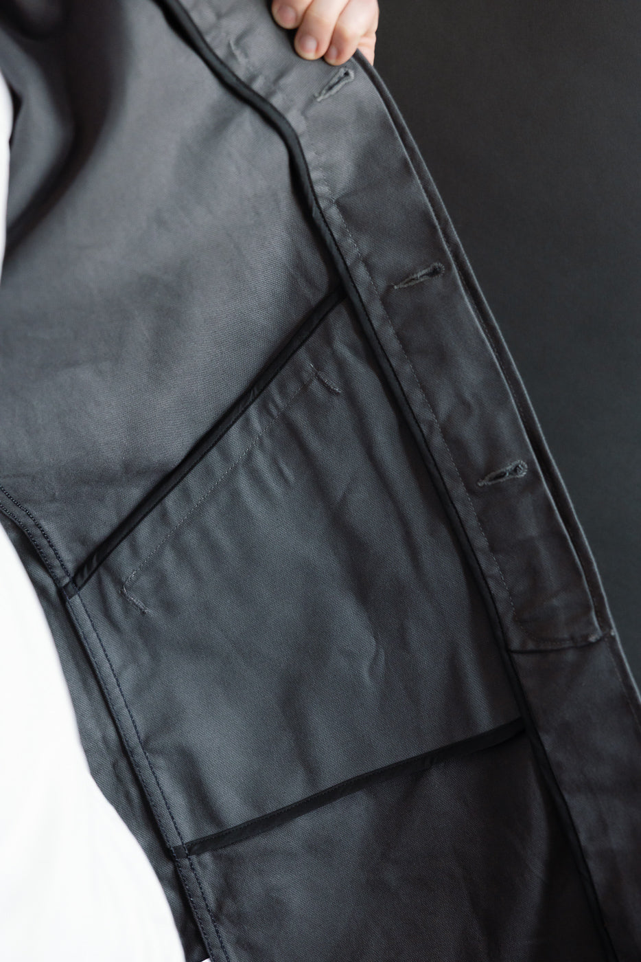 Close-up of inside front left panel of grey waxed canvas trench coat showing inner pocket detail
