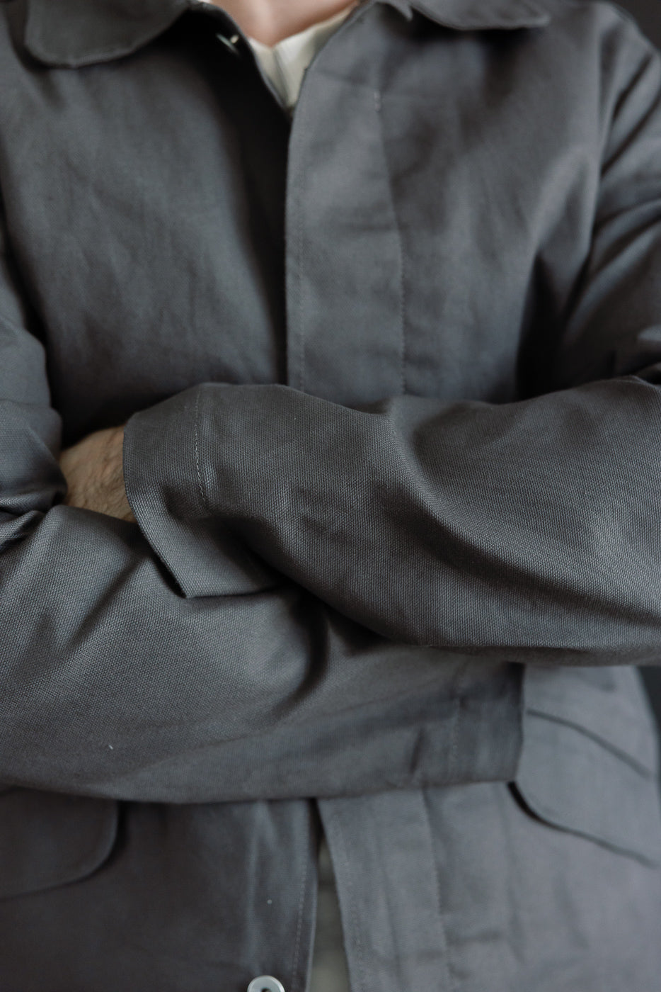 Close-up front view of grey waxed canvas trench coat on male model, 5'9