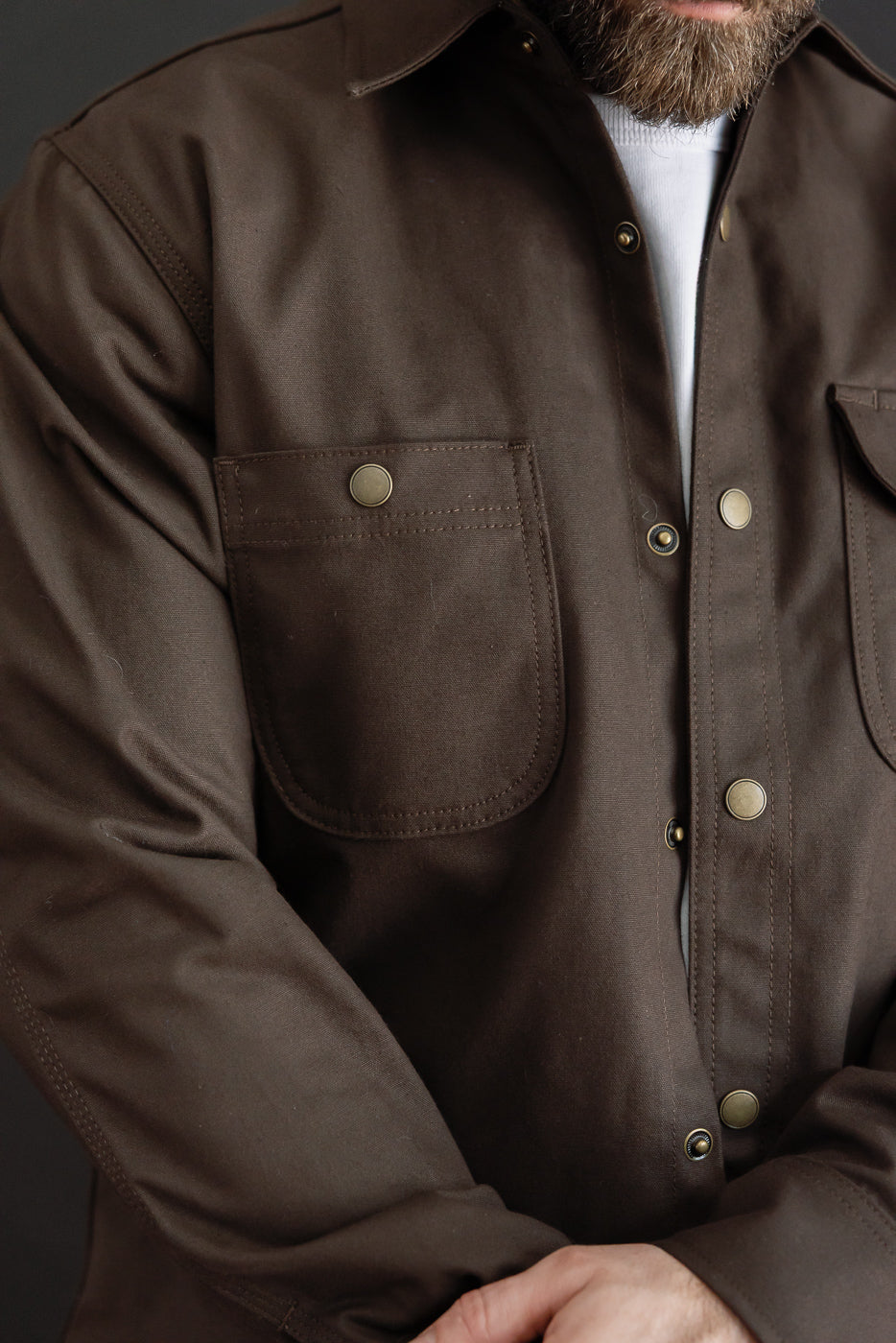 Close-up front view of a brown jacket on a male model (5'9