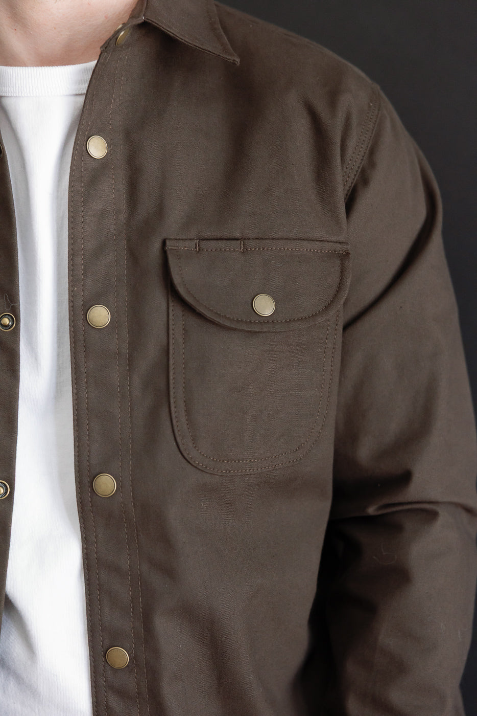 Close-up front view of a brown jacket on a male model (5'9
