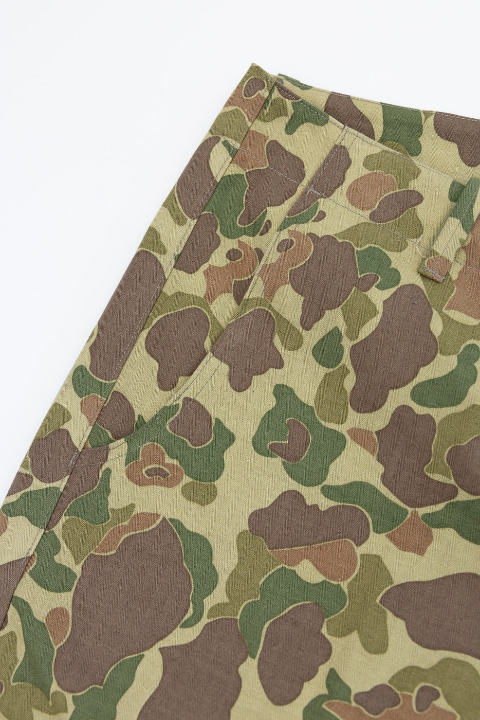 Close-up of camouflage pants front, showing fabric texture and stitching details