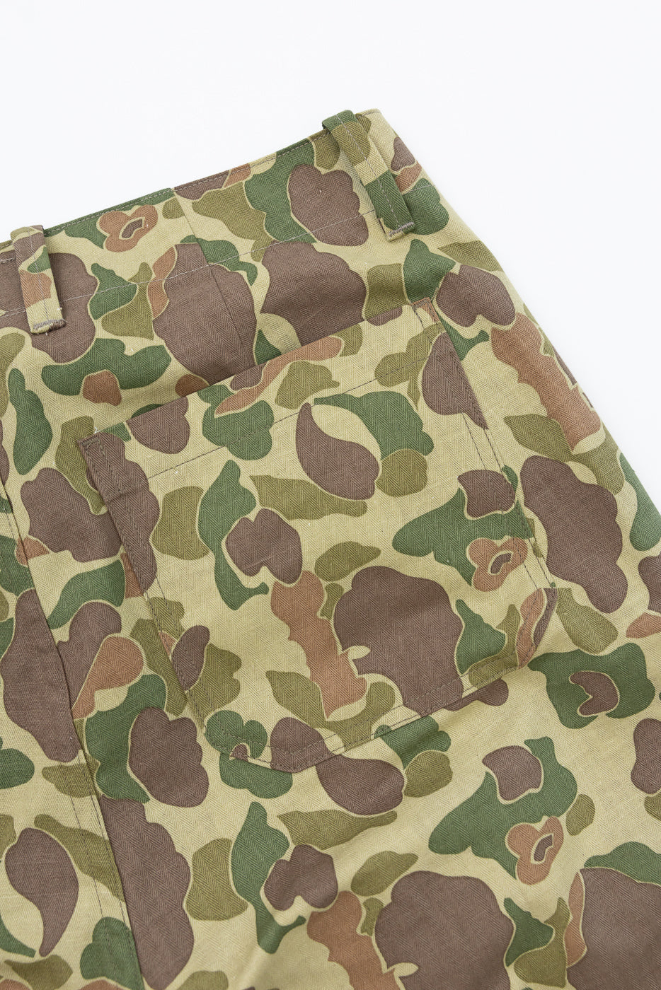 Close-up front view of camouflage pants with detailed pocket and fabric texture