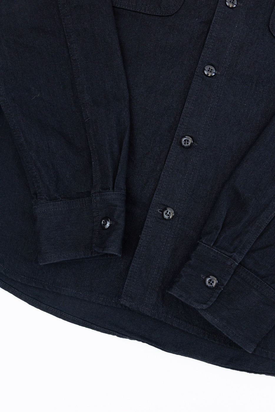 Close-up front view of dark denim shirt with button details and textured fabric