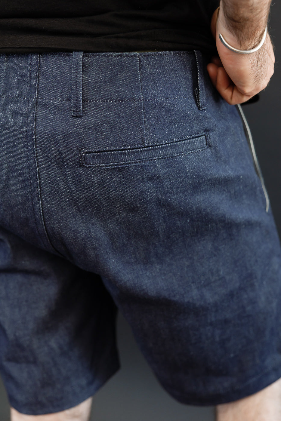 Back view of dark denim shorts, male model 5'9