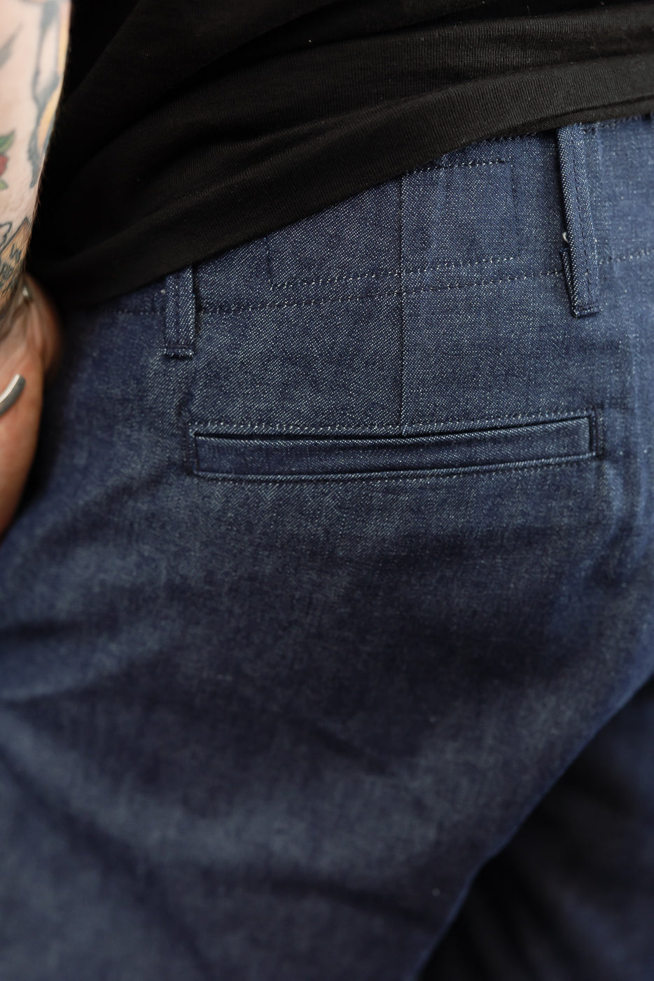 Close-up back view of dark denim pants on male model, 5'9
