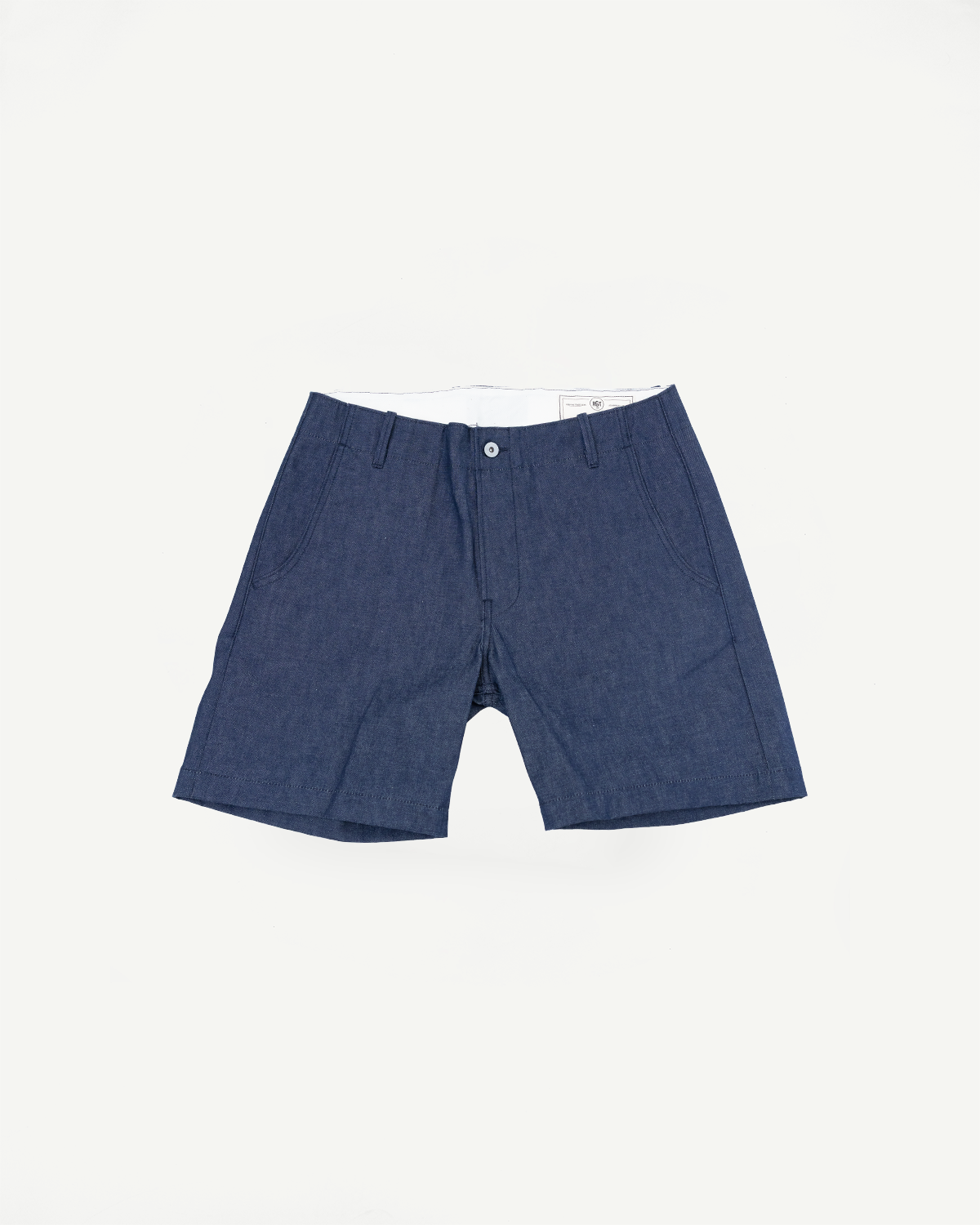 Front view flat lay of men's navy chambray shorts with button closure, side pockets, and clean hem