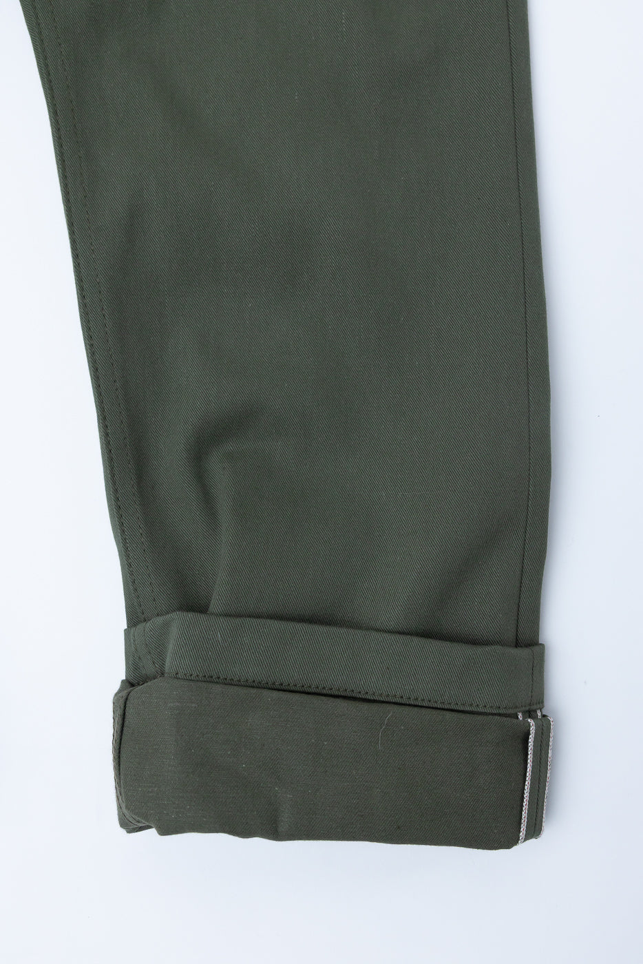Close-up of olive trouser leg cuff, showing front detail and fabric texture.