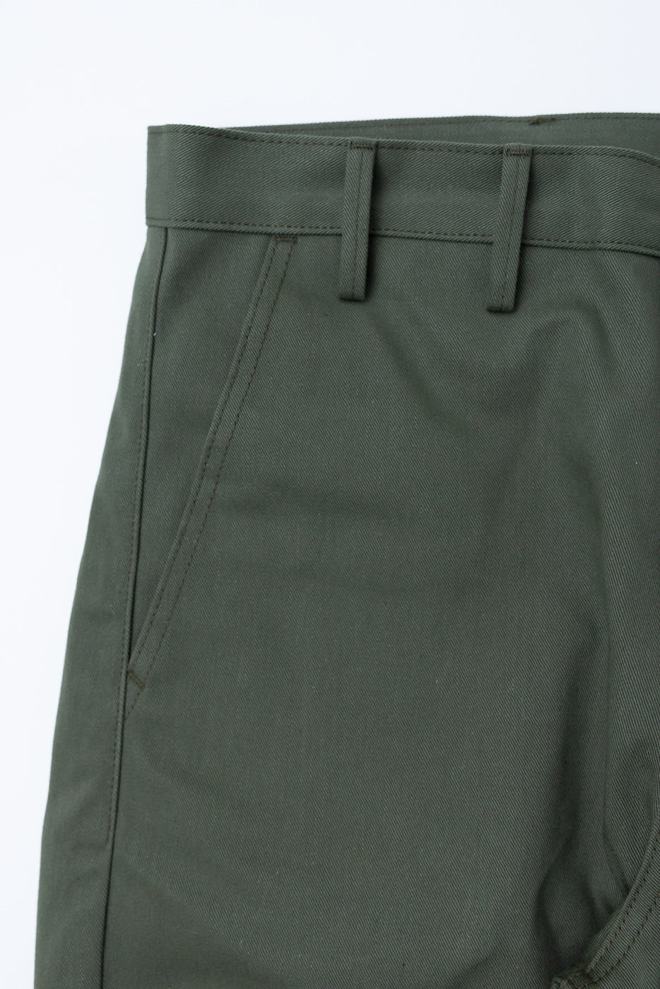 Close-up of front left waist and pocket area on olive green twill trouser showing belt loops and angled pocket.