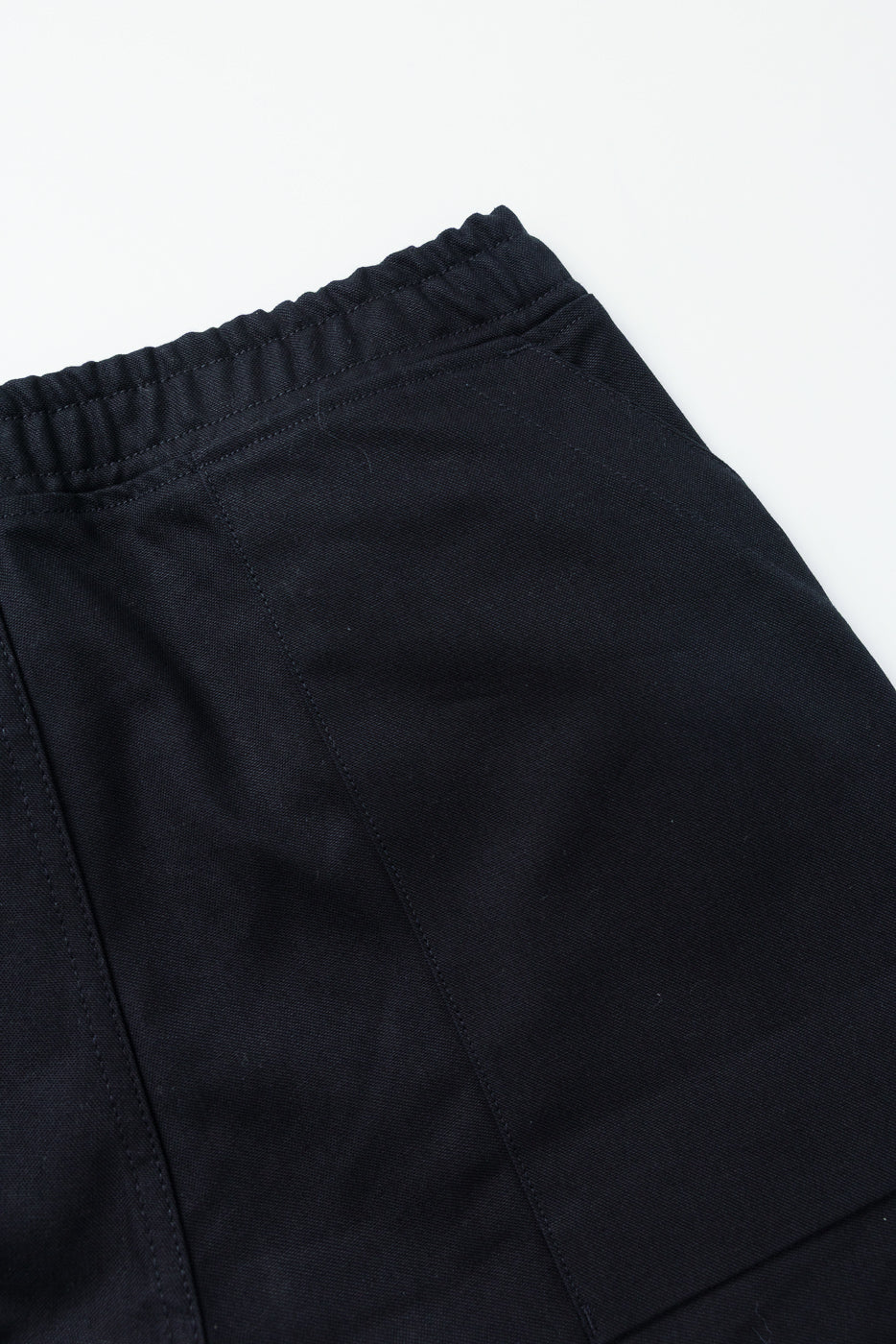 Close-up front view of black casual pants with elastic waistband and clean stitching detail
