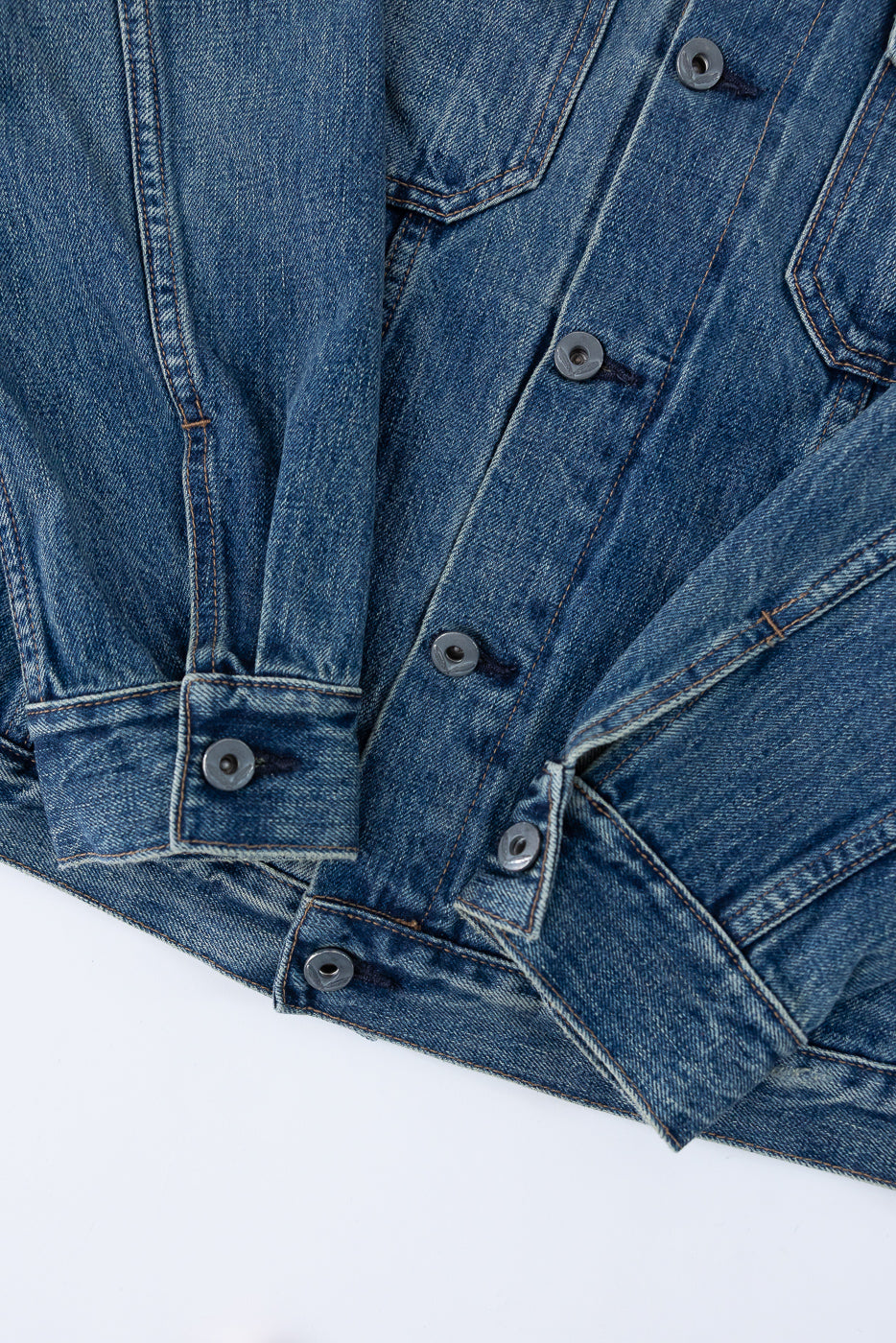 Close-up front view of denim jacket showing buttons, stitching, and fabric texture