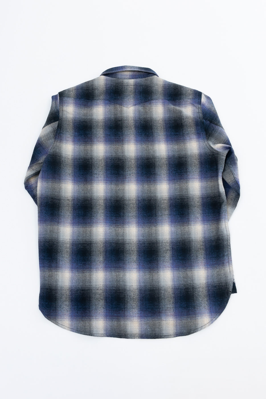 Back view flat lay of a blue and grey plaid flannel shirt with a curved hem.