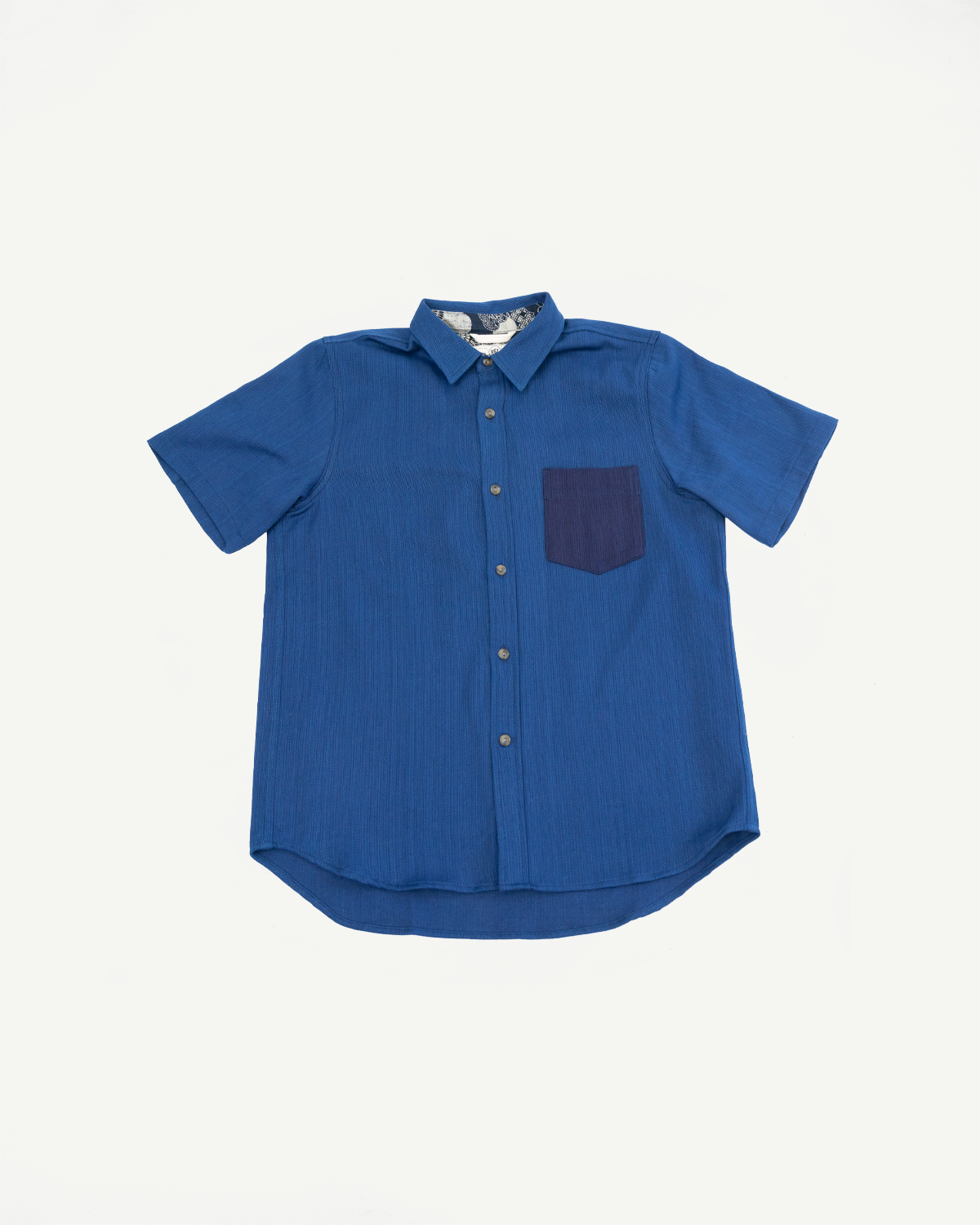 Blue short-sleeve shirt front view, ribbed texture, contrast pocket, button-down collar