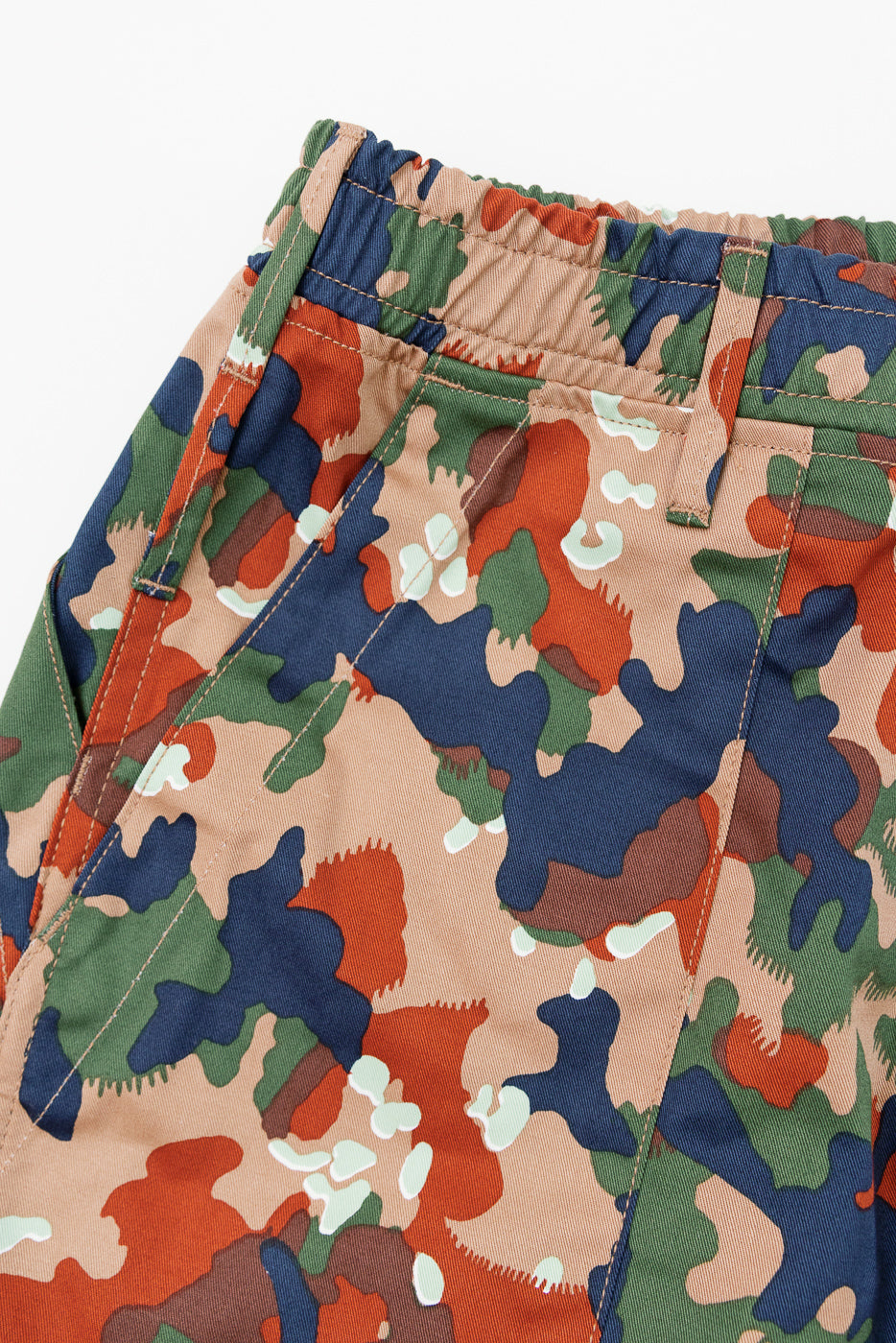 Close-up front view of camo pants with elastic waistband, multi-color pattern, and visible stitching details