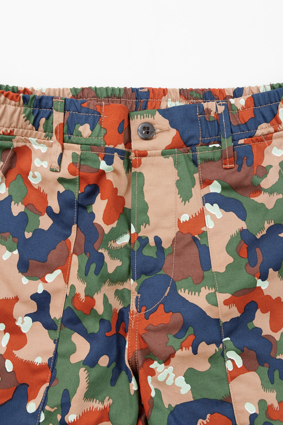 Close-up front view of camo shorts with button closure, elastic waist, and visible stitching detail.