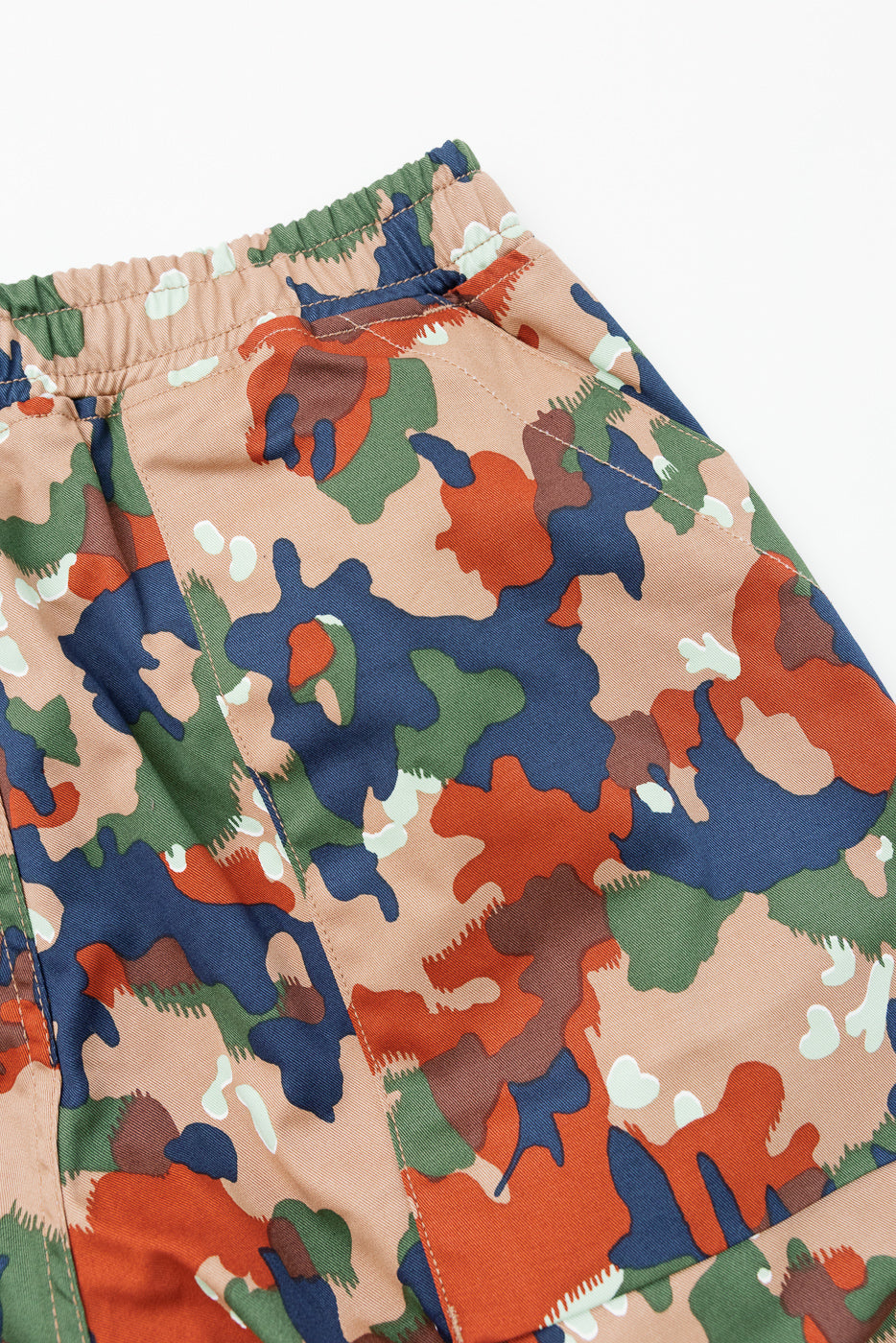 Close-up front view of camo shorts with elastic waistband, showcasing fabric texture and color pattern.