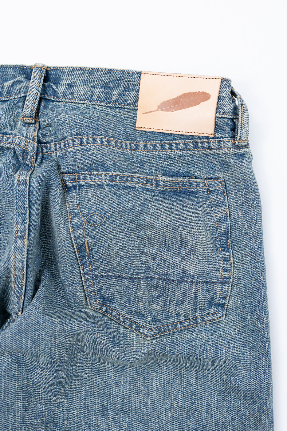 Close-up of Rogue Territory Stanton 15oz river washed selvedge jeans, back side, showing rear pocket and leather brand patch detail.