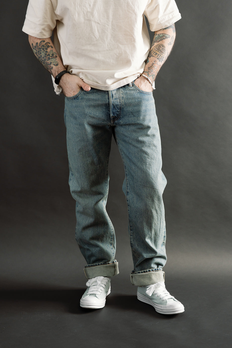 Front view, mid-body of male model 5'9 165lbs athletic build wearing Rogue Territory RGT 15oz river washed selvedge Stanton jeans in indigo, cuffed, with visible denim texture
