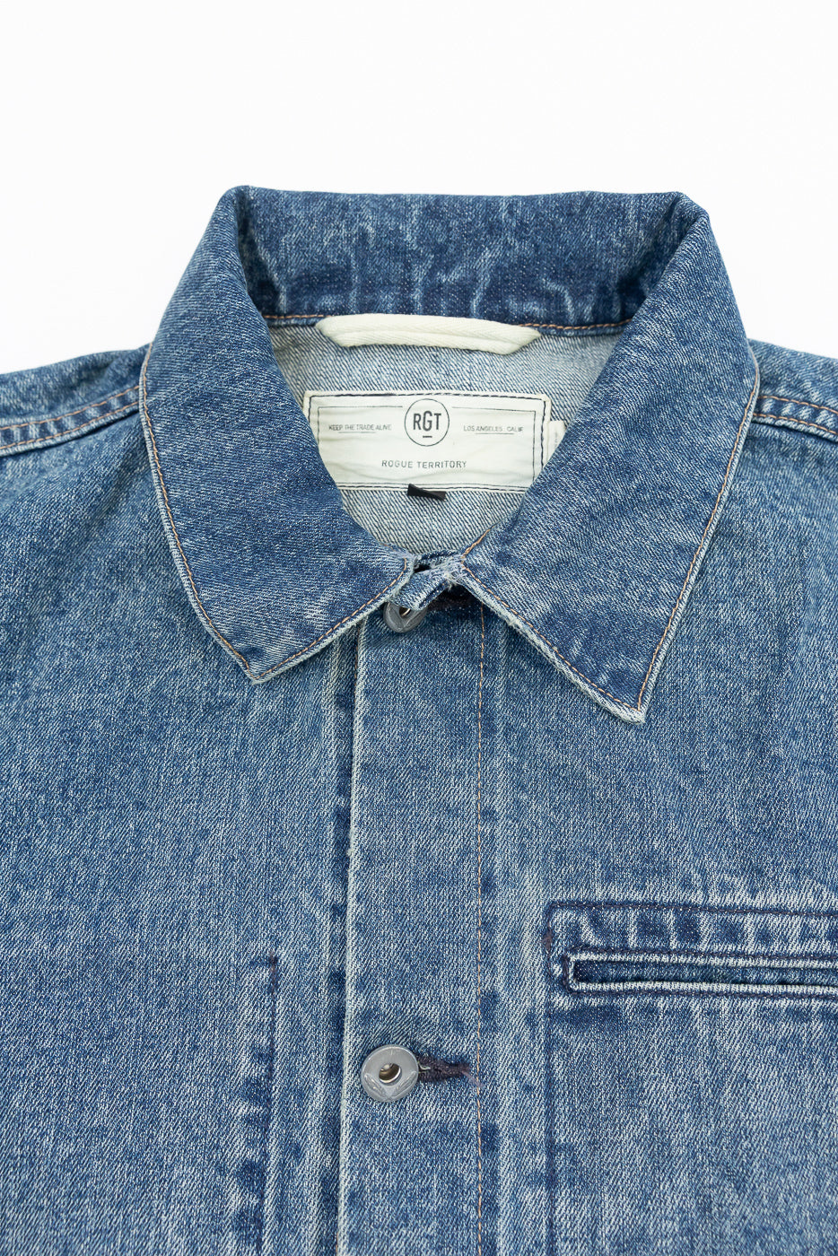 Close-up front view of men's denim shirt collar, buttons, and tag details