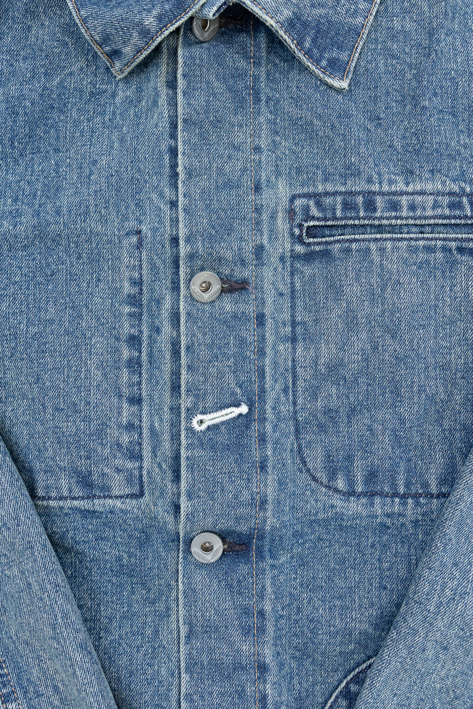 Close-up front view of denim shirt showing buttons, collar, and chest pocket details