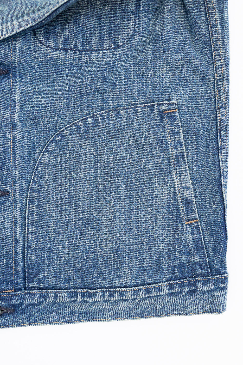 Close-up of front denim jacket pocket, showcasing texture and stitching details