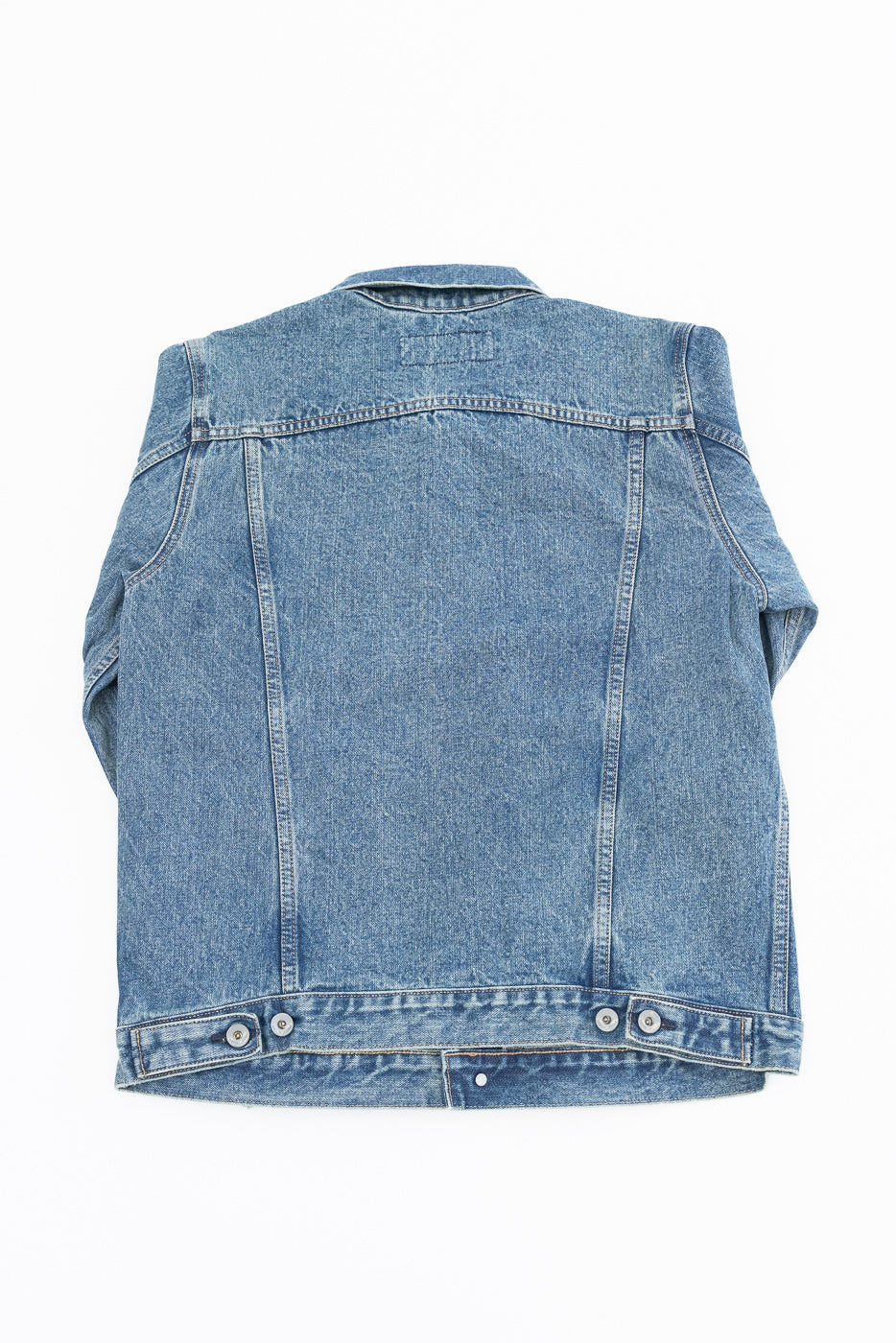 Back view of men's denim jacket, showcasing buttoned hem and fabric texture