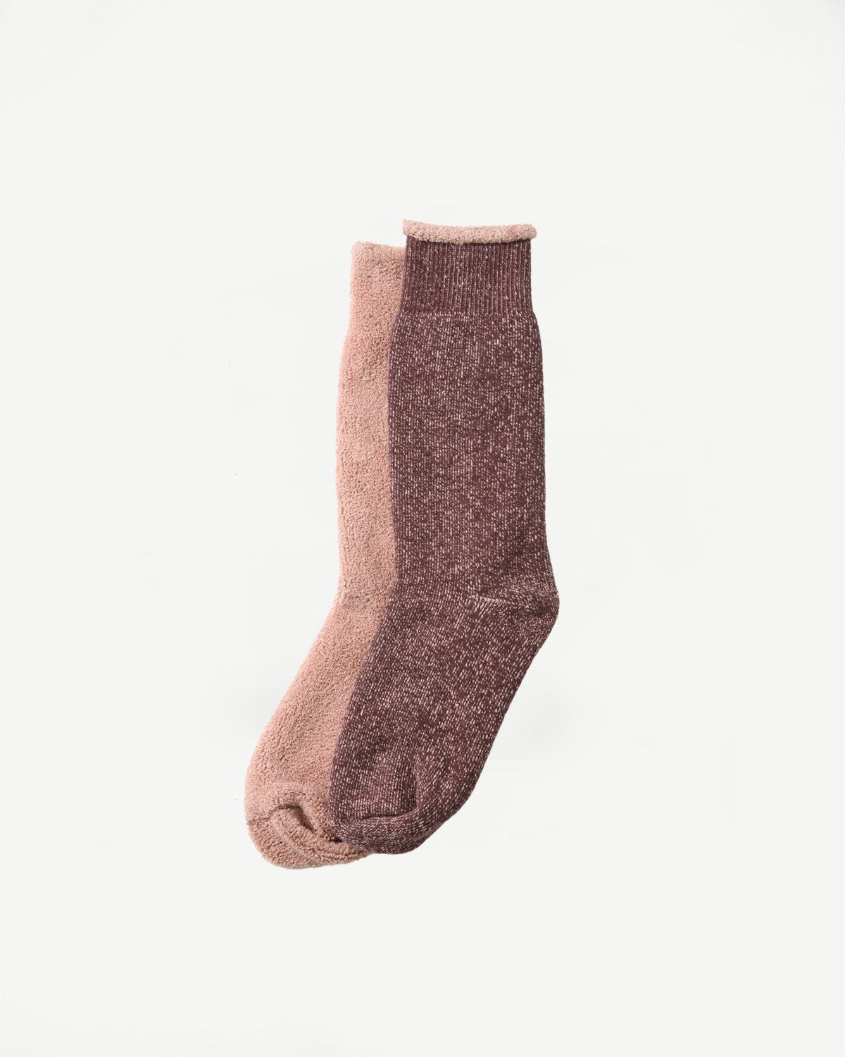 Close-up side view of a pair of textured cotton socks in dusty pink and maroon.