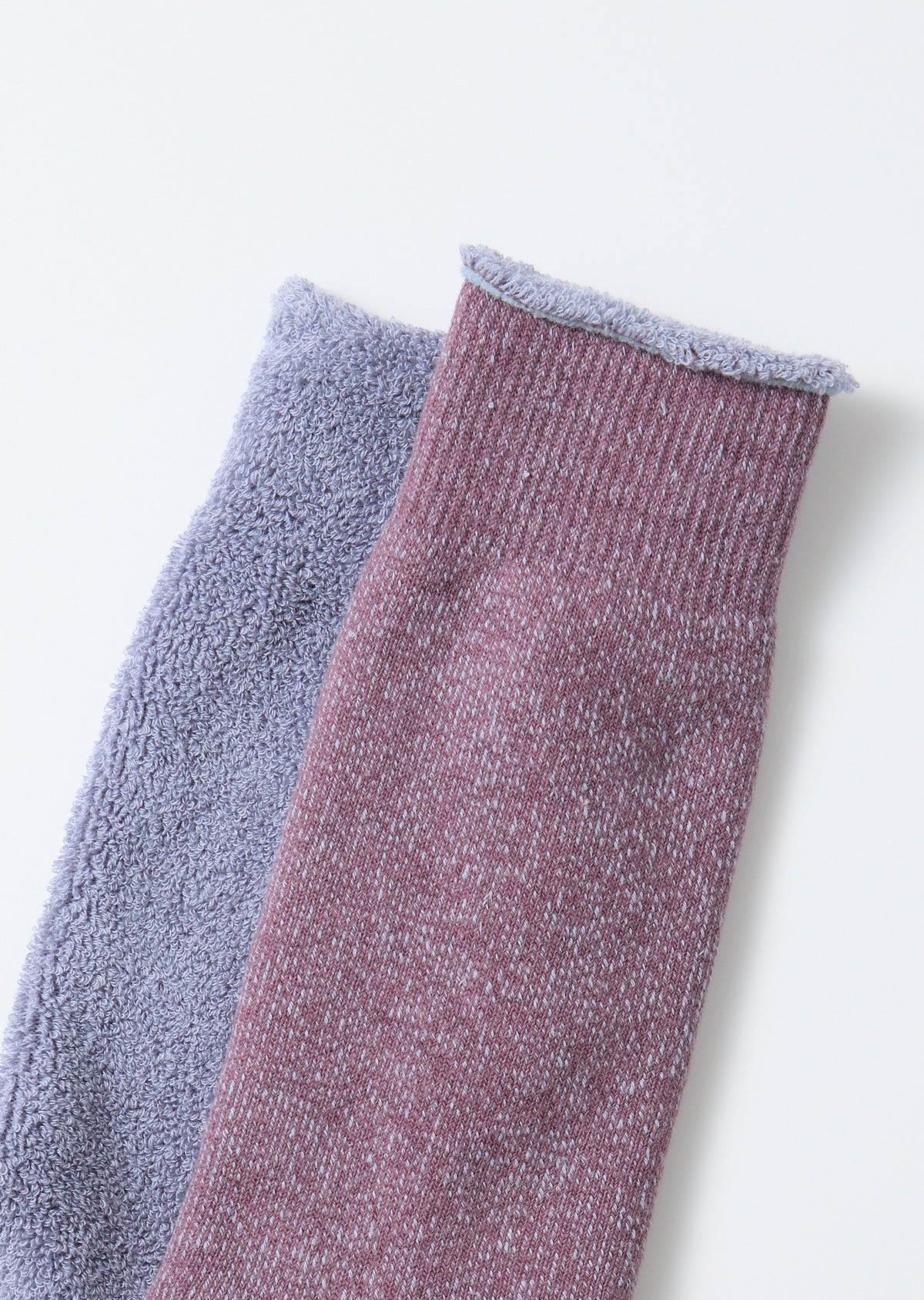 Close-up of the ribbed texture and hem of a mauve and lavender sock.