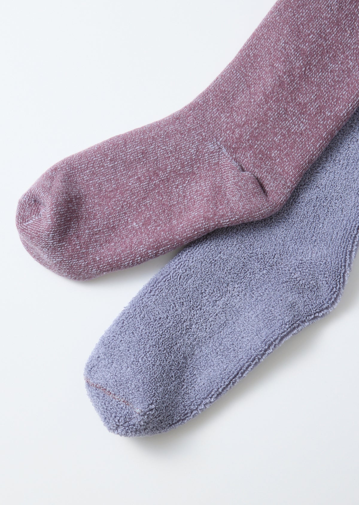 Close-up of the front view showing the thick, textured fabric of a pink and a purple sock.