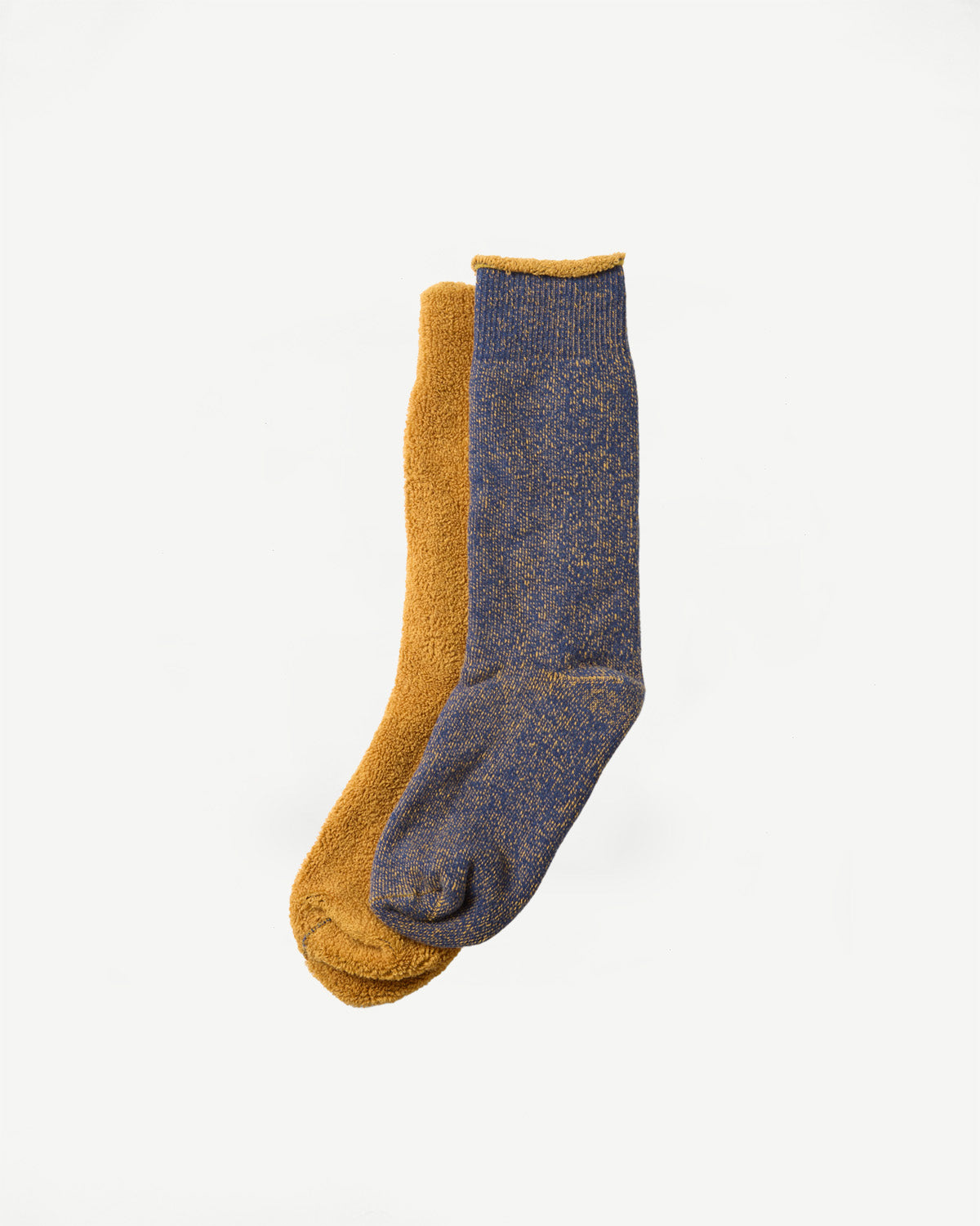 Flat lay of a pair of mustard yellow and navy blue speckled crew socks, showing the front side.