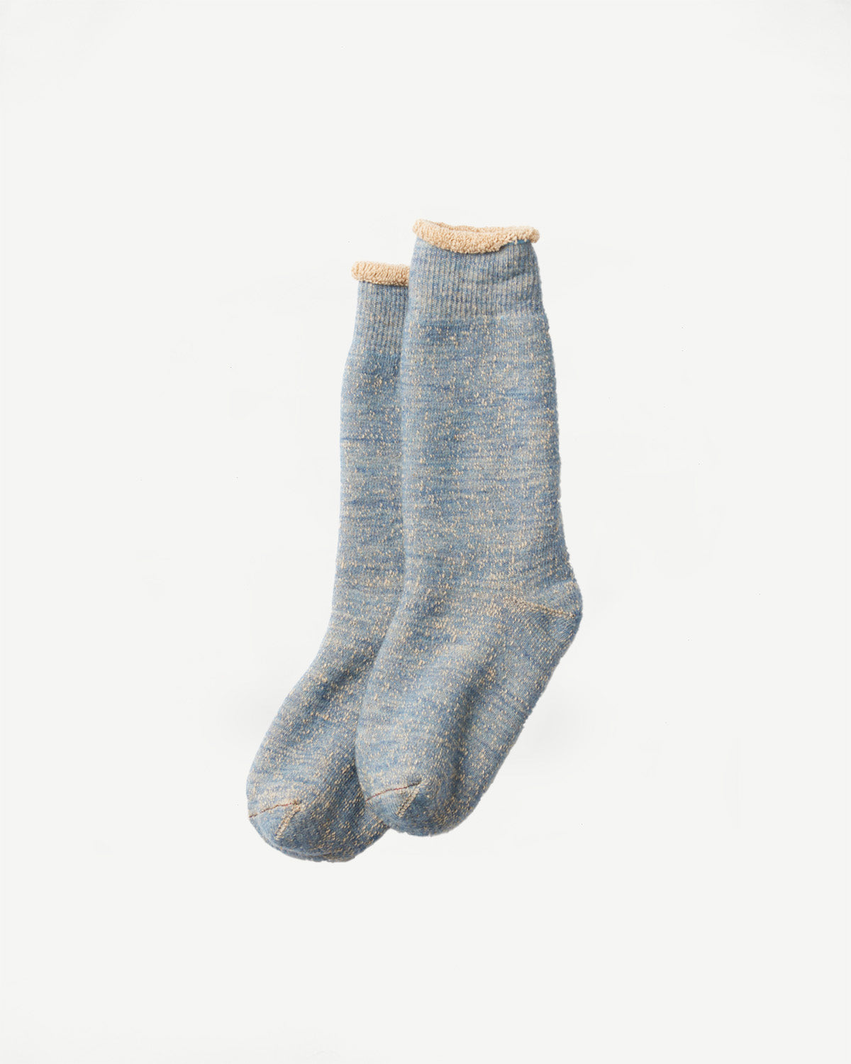 Close-up front view of a pair of light blue speckled knit crew socks.