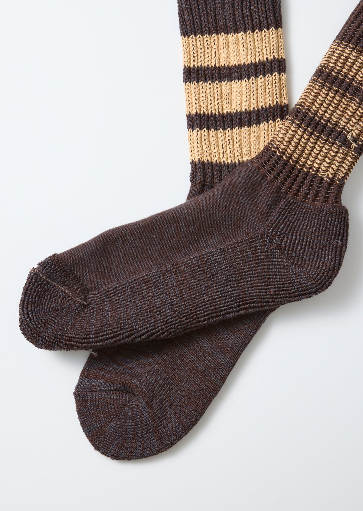 Close-up flat lay of brown and tan striped socks, showing the heel and toe fabric texture.