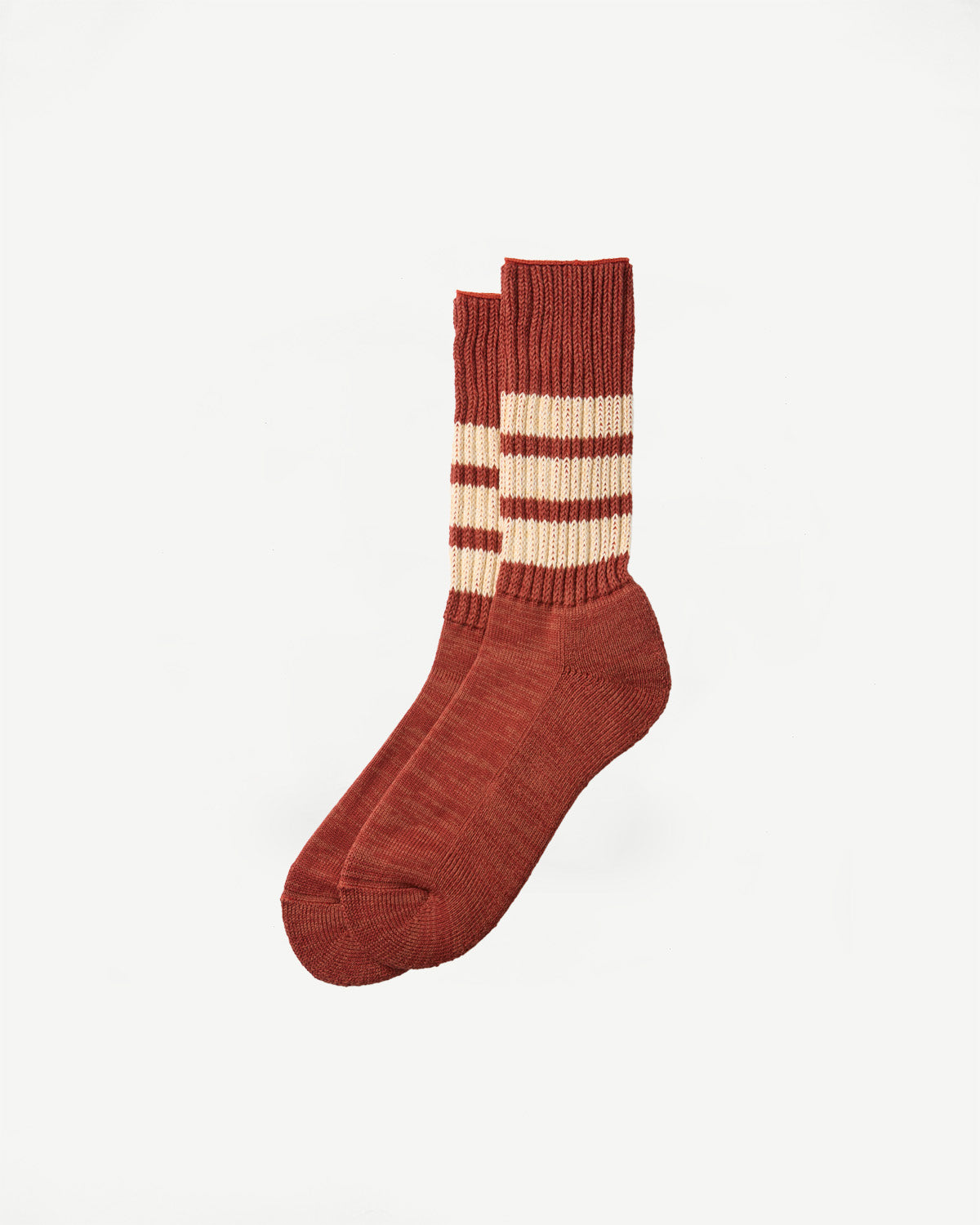 Flat lay, side view of rust-colored ribbed crew socks with cream horizontal stripes.