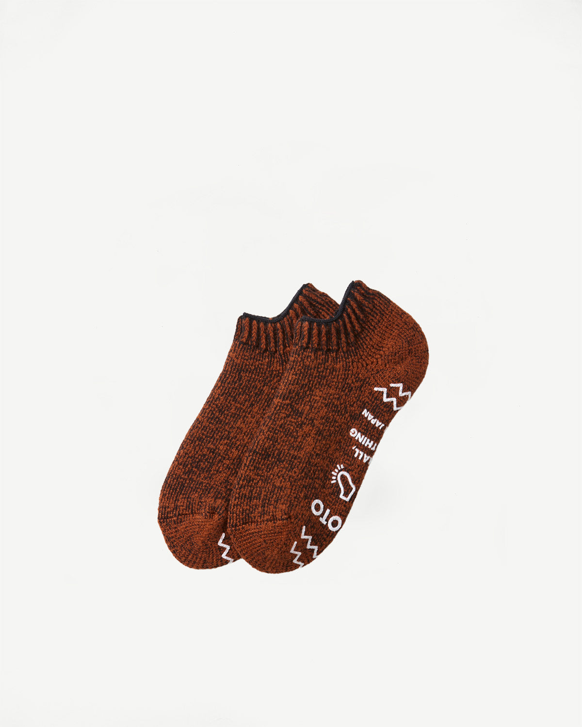 Close-up of the front of a pair of brown textured socks with white patterns.