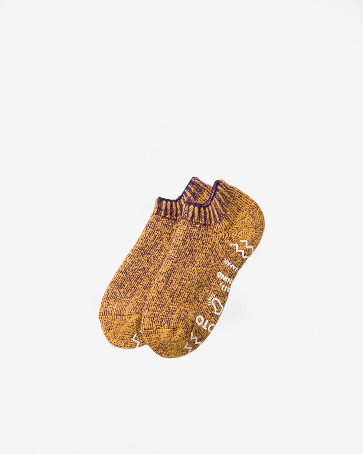 Close-up front view of a pair of mustard yellow marl knit socks with white text details.