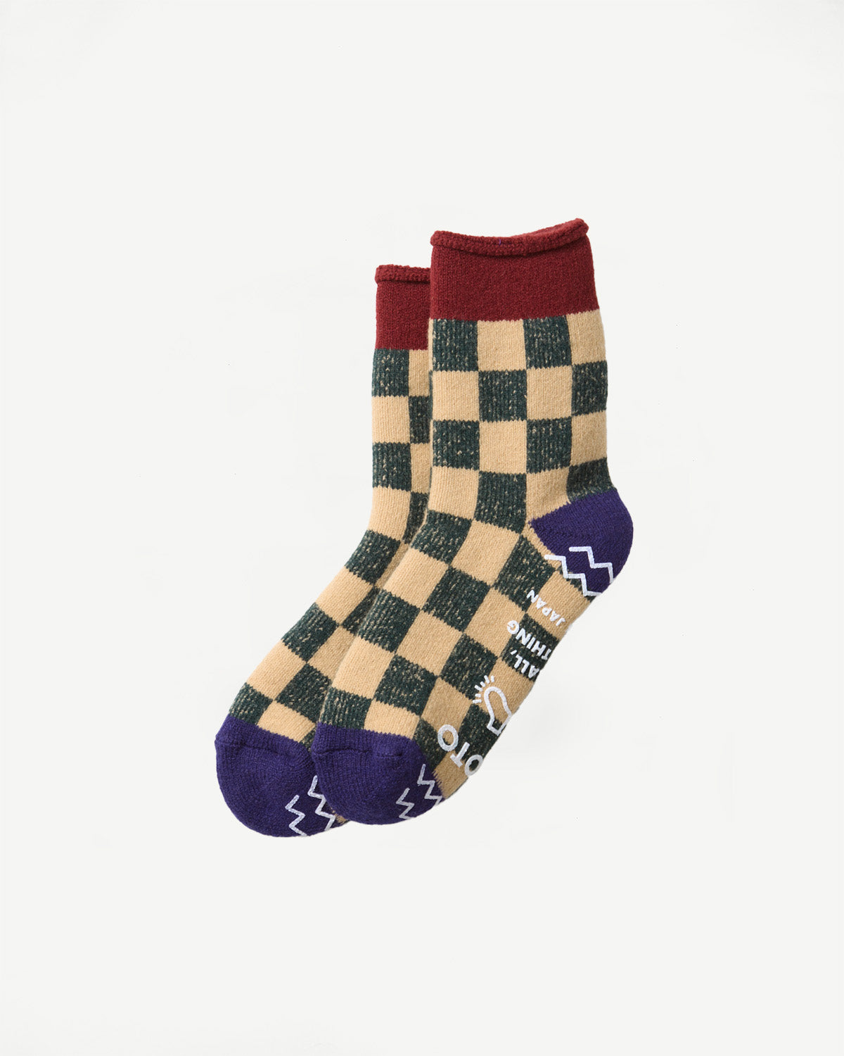 Flat lay of the front view of a pair of tan and dark green checkered socks with purple toes and heels.