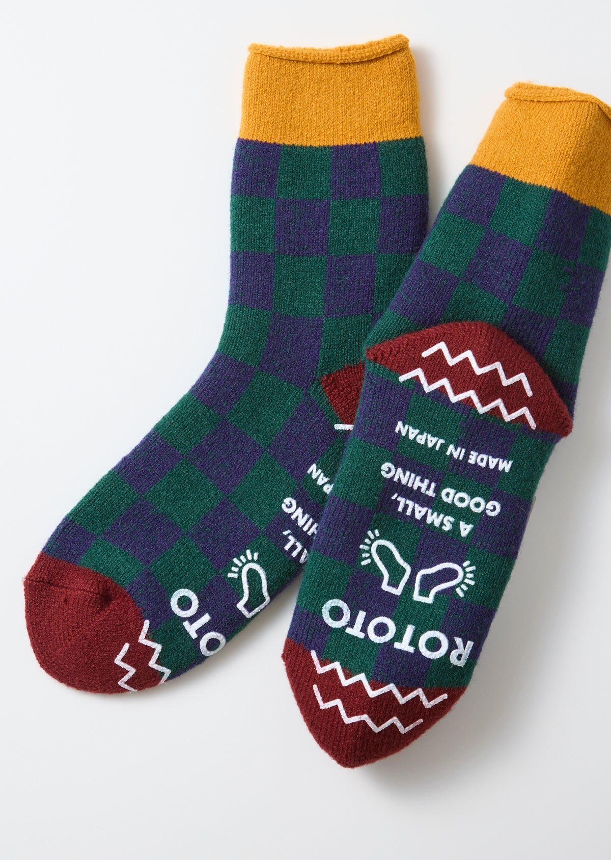 Flat lay front view of checkered green and purple socks with maroon toe and heel details.