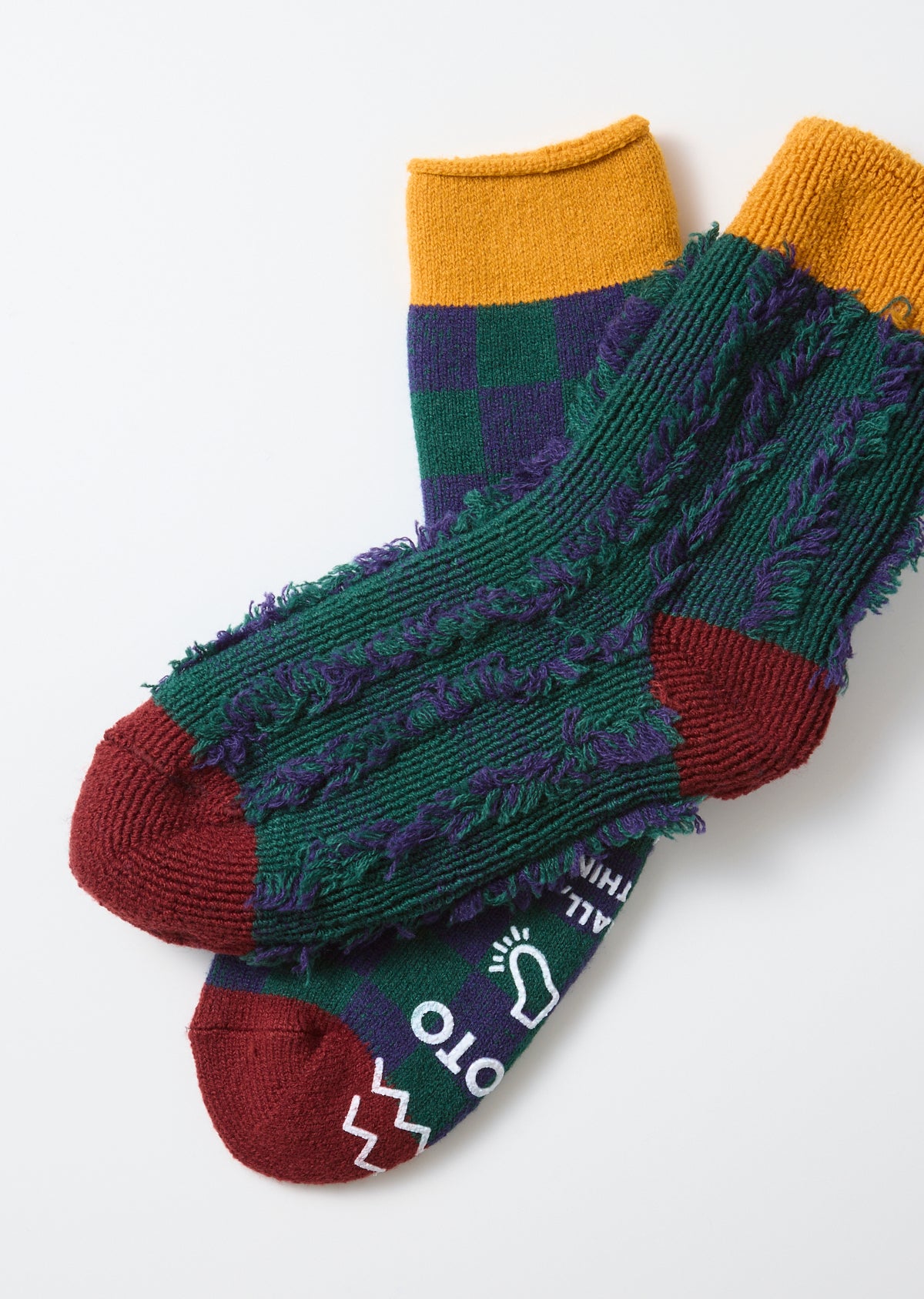 Flat lay front view of textured green and purple checkered socks with burgundy toes.
