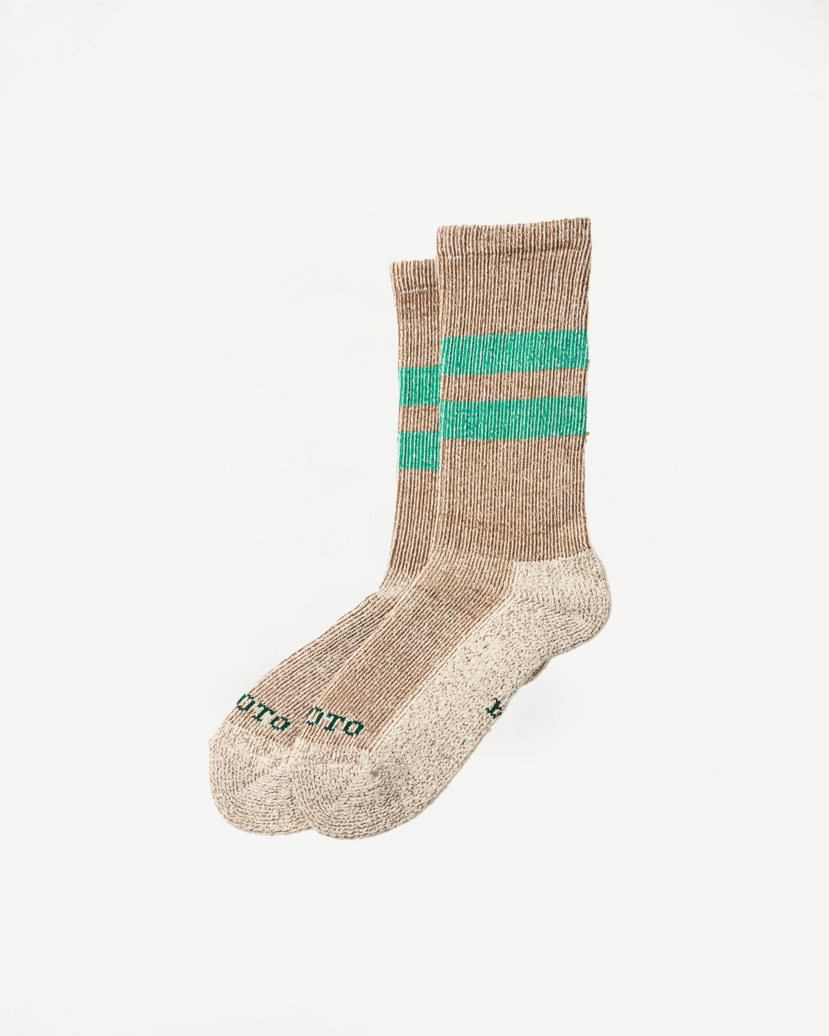 Flat lay, side view of a pair of tan ribbed crew socks with green stripes and 'UTO' text.