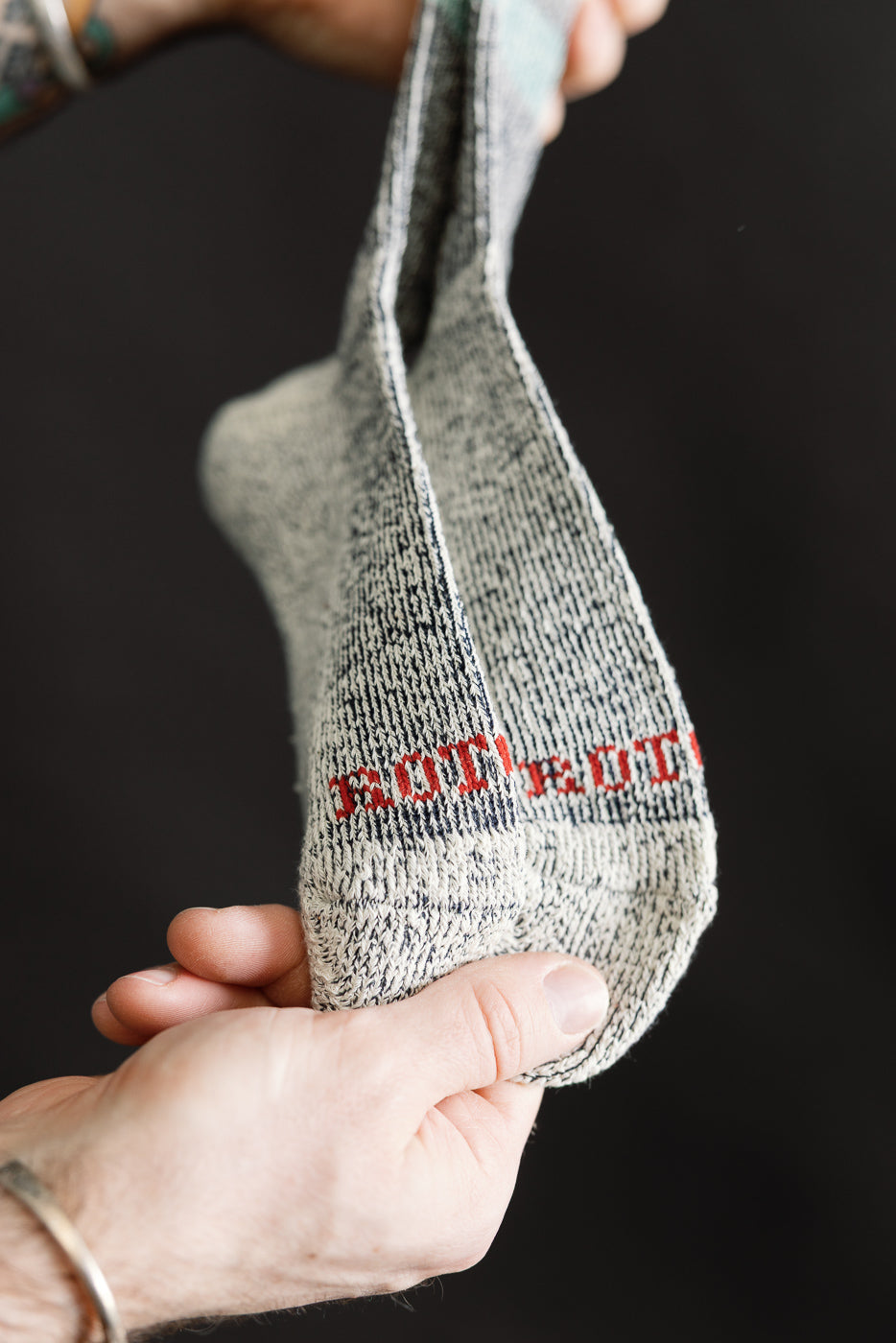 Close-up of underside of navy marl stripe socks, showing knit texture and red stitched detail.