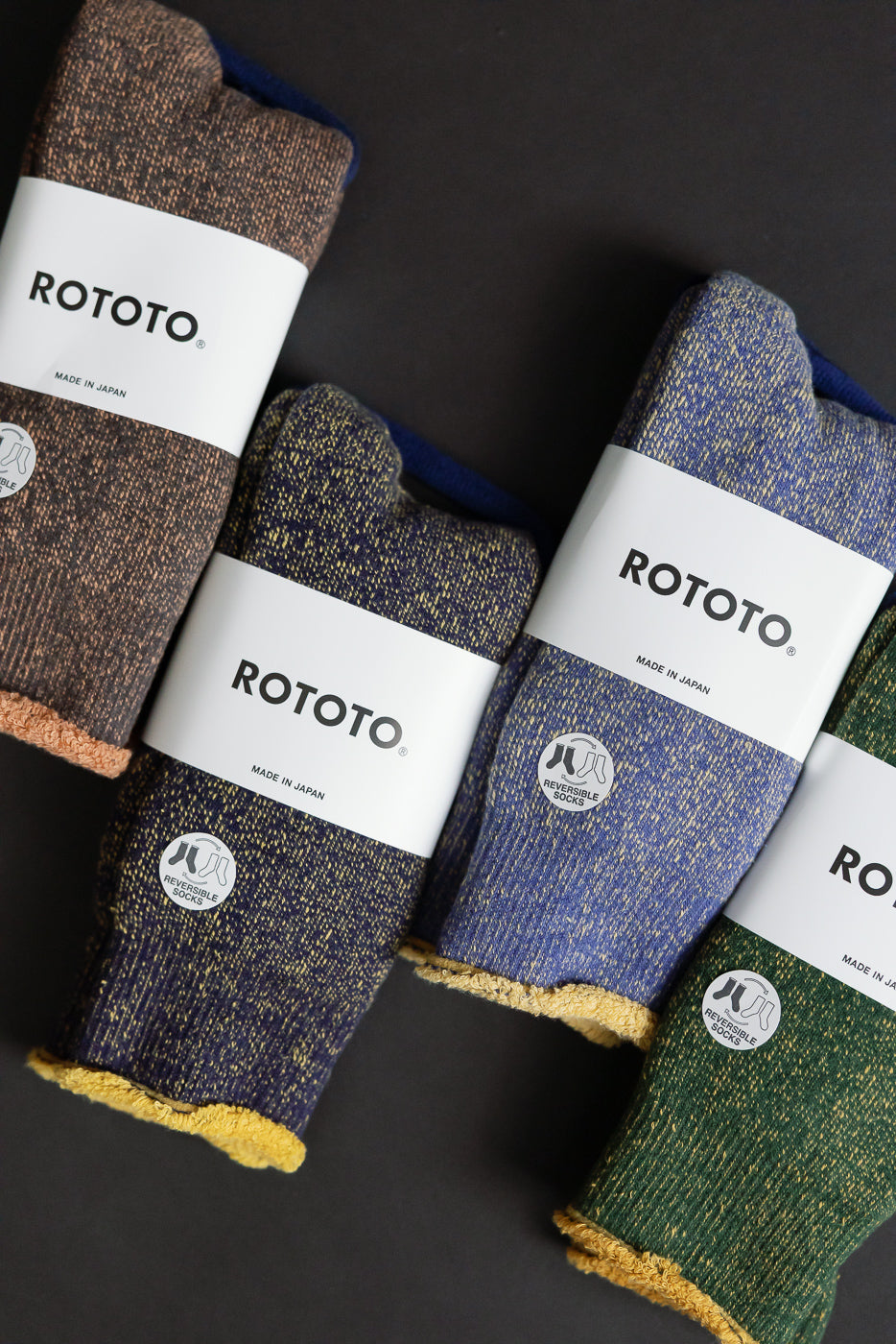 R1612 - Reversible Pile Socks by ROTOTO, featuring a speckled-knit design in brown, navy, blue, and green. Each pair has a white band labeled Made in Japan and reversible wear options.