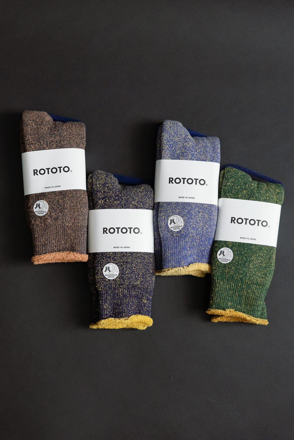 R1612 - Reversible Pile Socks by ROTOTO, showcasing four tabi knit pairs, wrapped in white labels, highlighting their two-tone, reversible design and substantial knit, inspired by 1970s college T-shirts.