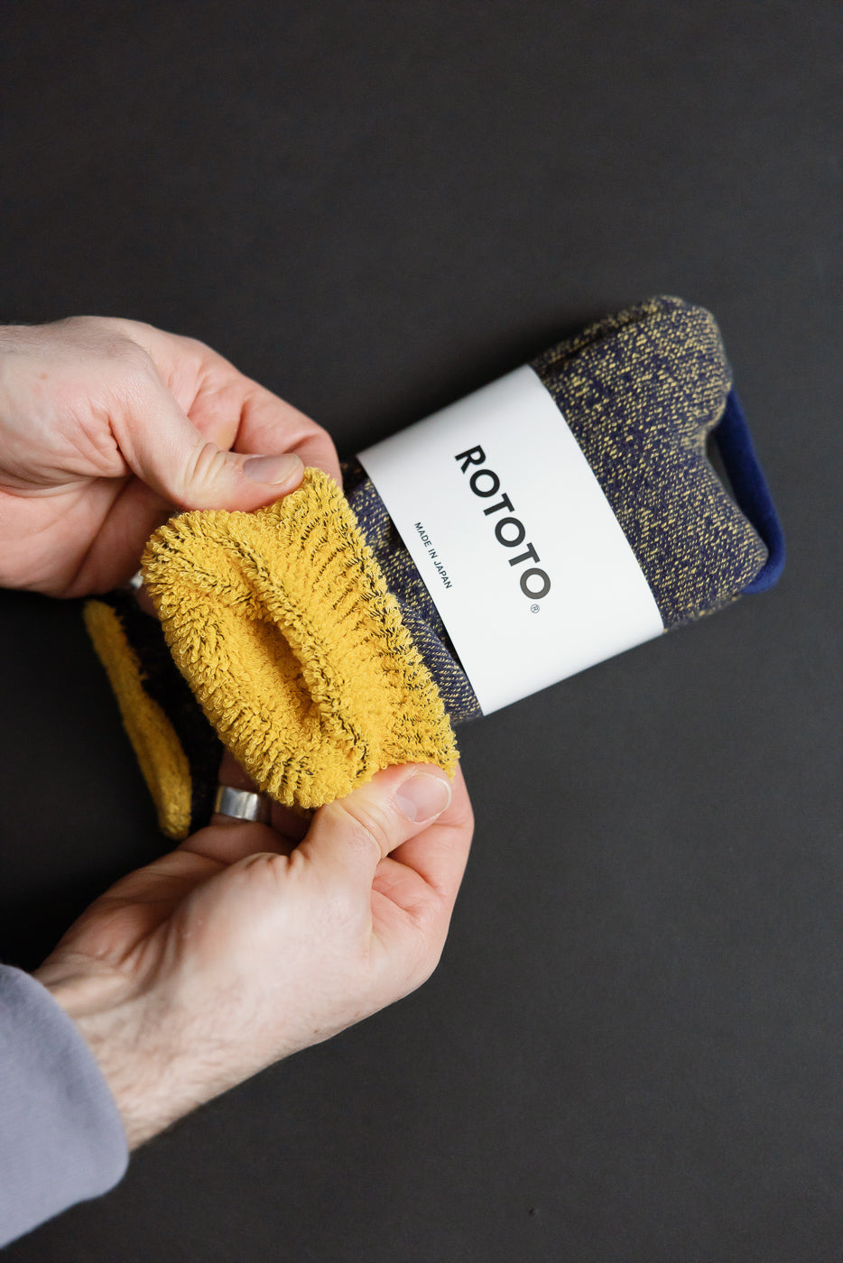 R1612 - Reversible Pile Socks - Navy, Yellow, featuring a folded pair showing both the flecked and solid mustard-yellow sides, wrapped in a branded ROTOTO – Made in Japan paper band.