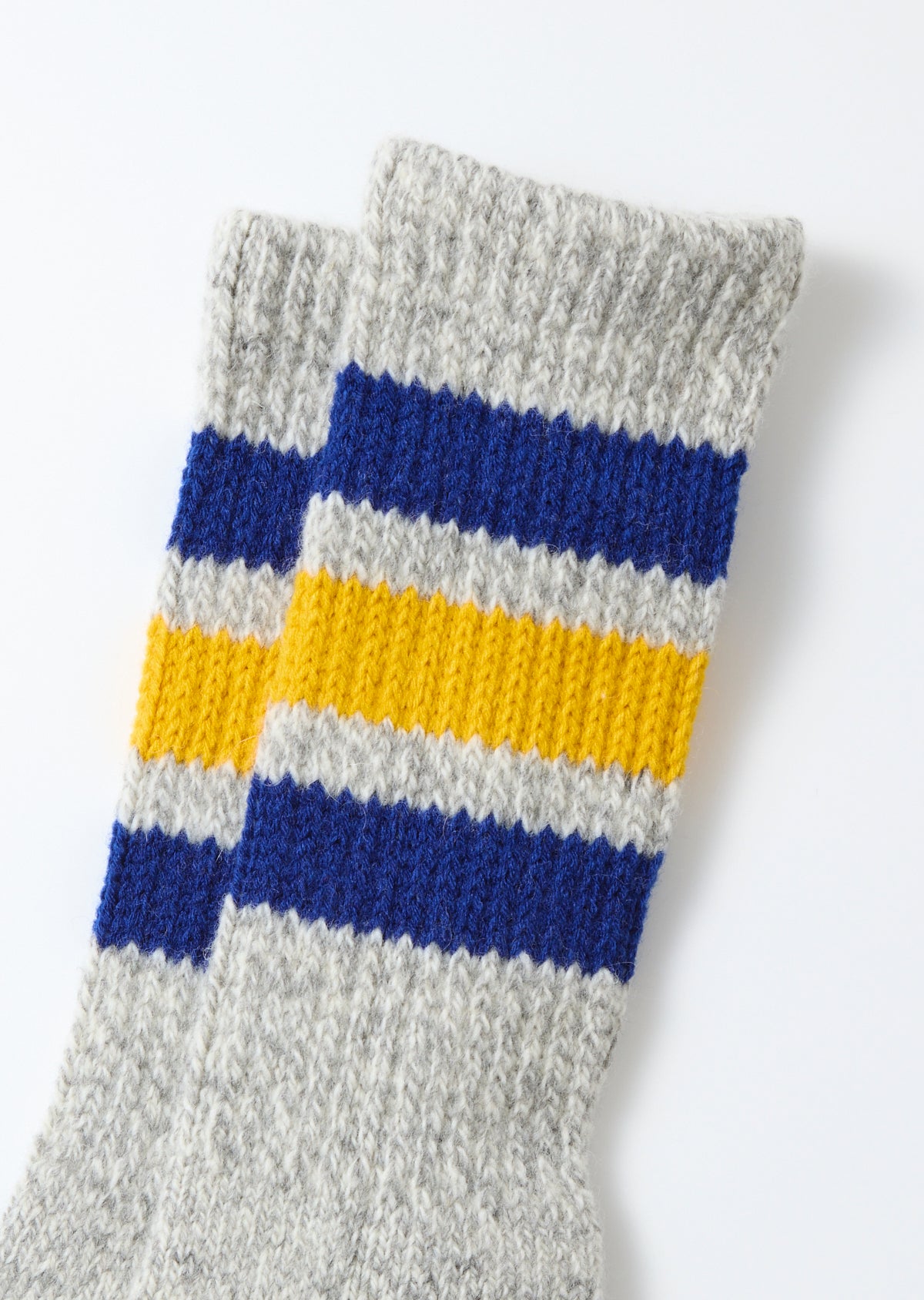 Close-up front view of grey knit socks with blue and yellow stripes.