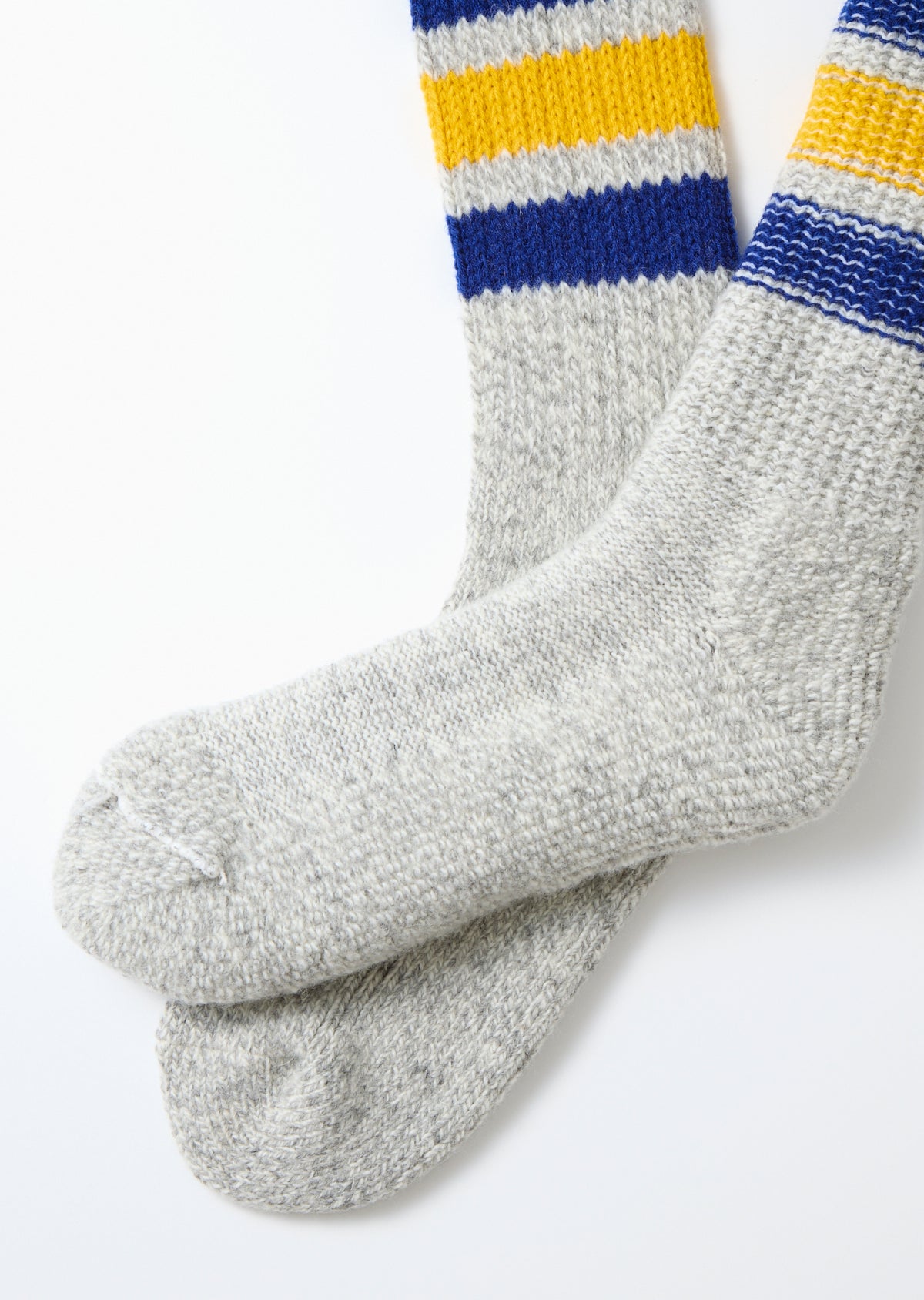 Close-up of the front view of grey marl knit socks with blue and yellow stripes at the top.