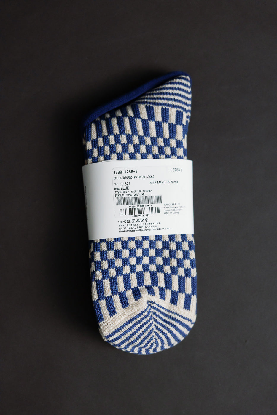 Flat lay of blue and cream checkerboard crew socks, front view with label and toe detail visible.