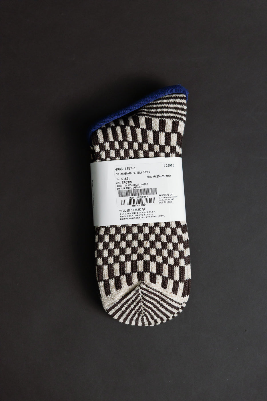 Close-up of brown checkerboard crew socks, flat lay, showing front with product label details.