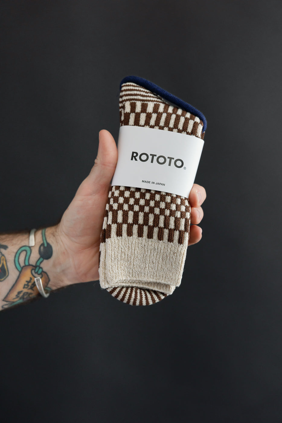 Close-up front view of Rototo patterned socks with a brown and cream checkerboard design.