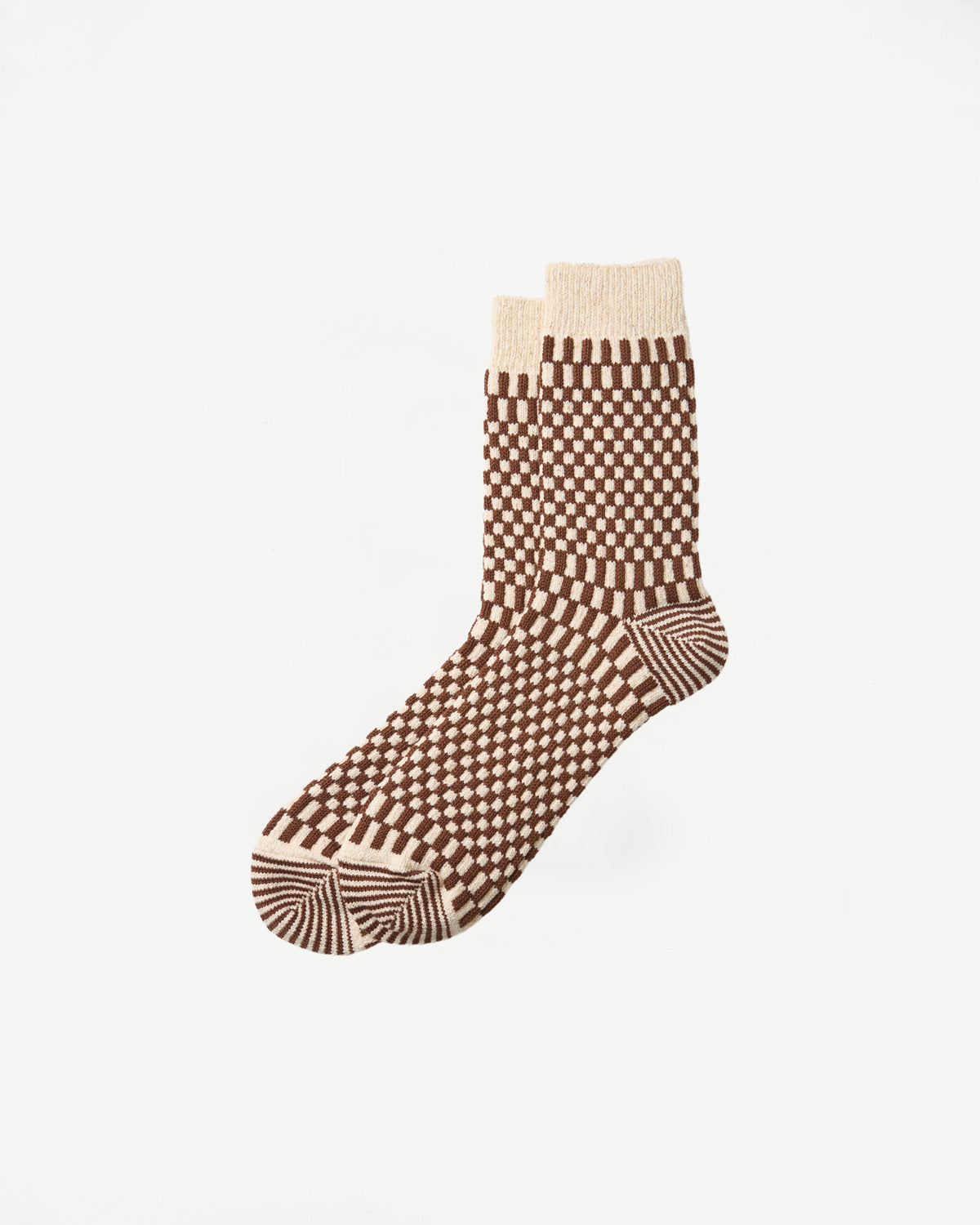 Flat lay of a pair of patterned crew socks in brown and cream checkered design.